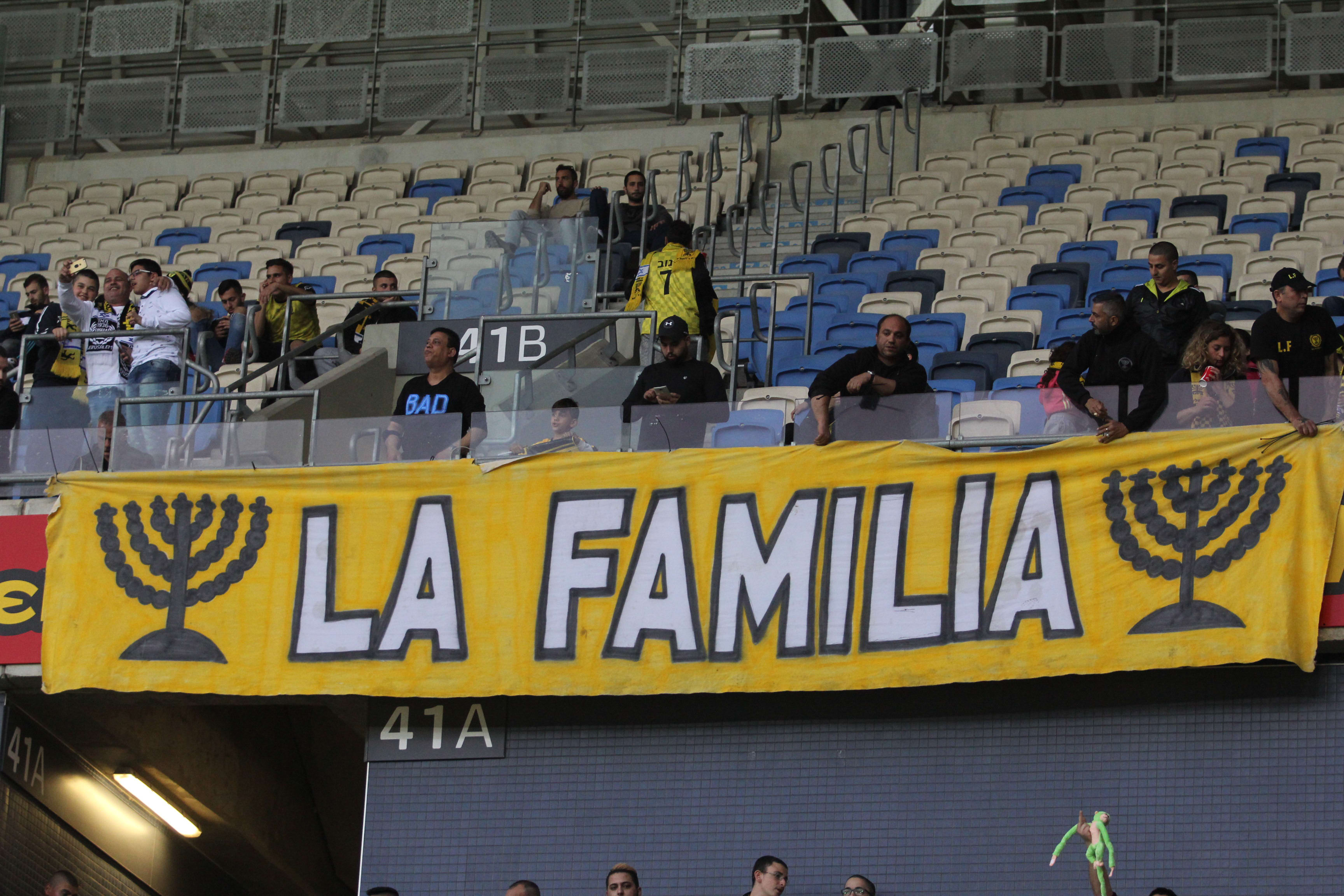 שלט של לה פמיליה ביציע אוהדי בית"ר ירושלים