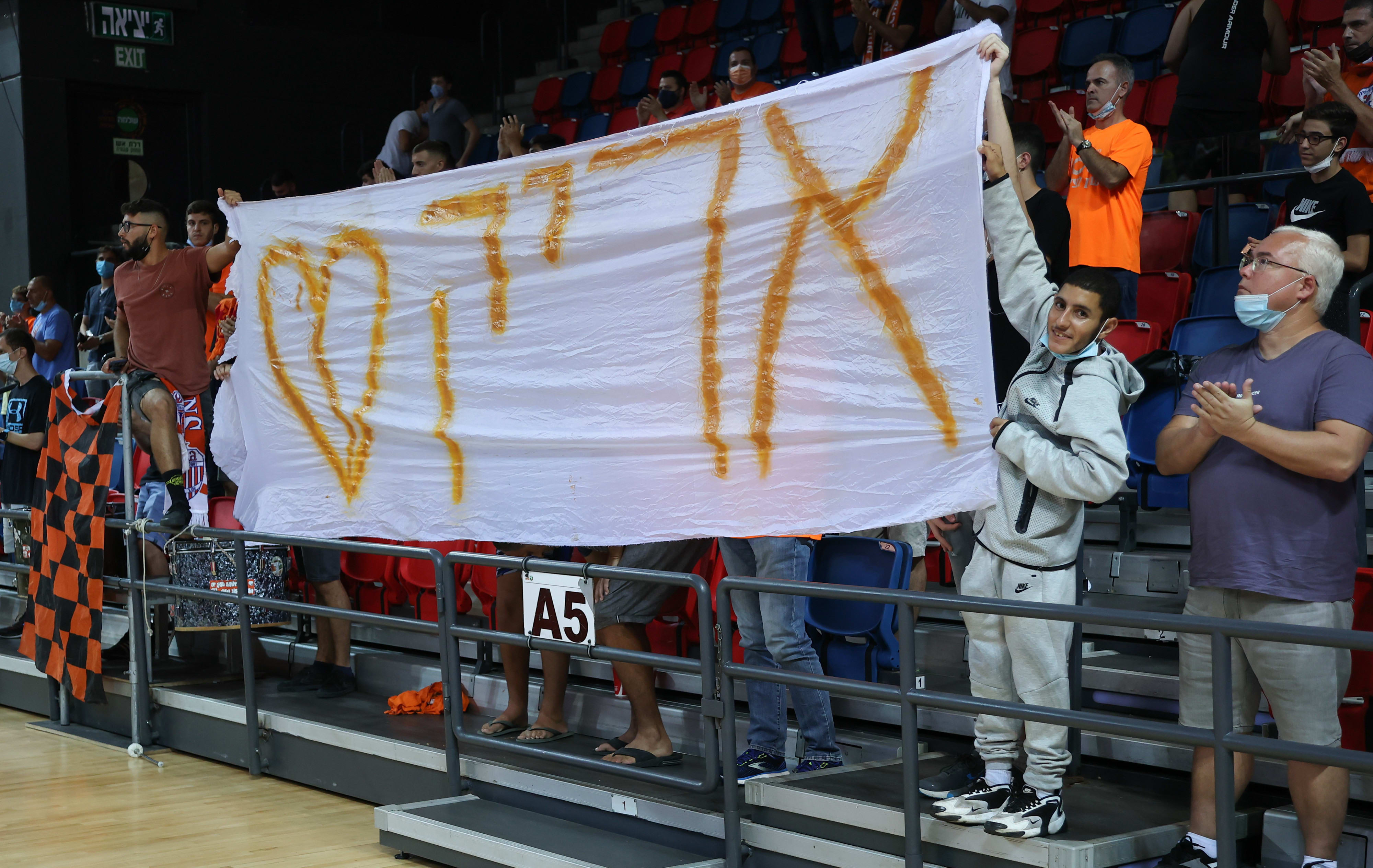 אוהדי מכבי ראשון לציון עם שלט לזכרו של אריק אלפסי ז"ל