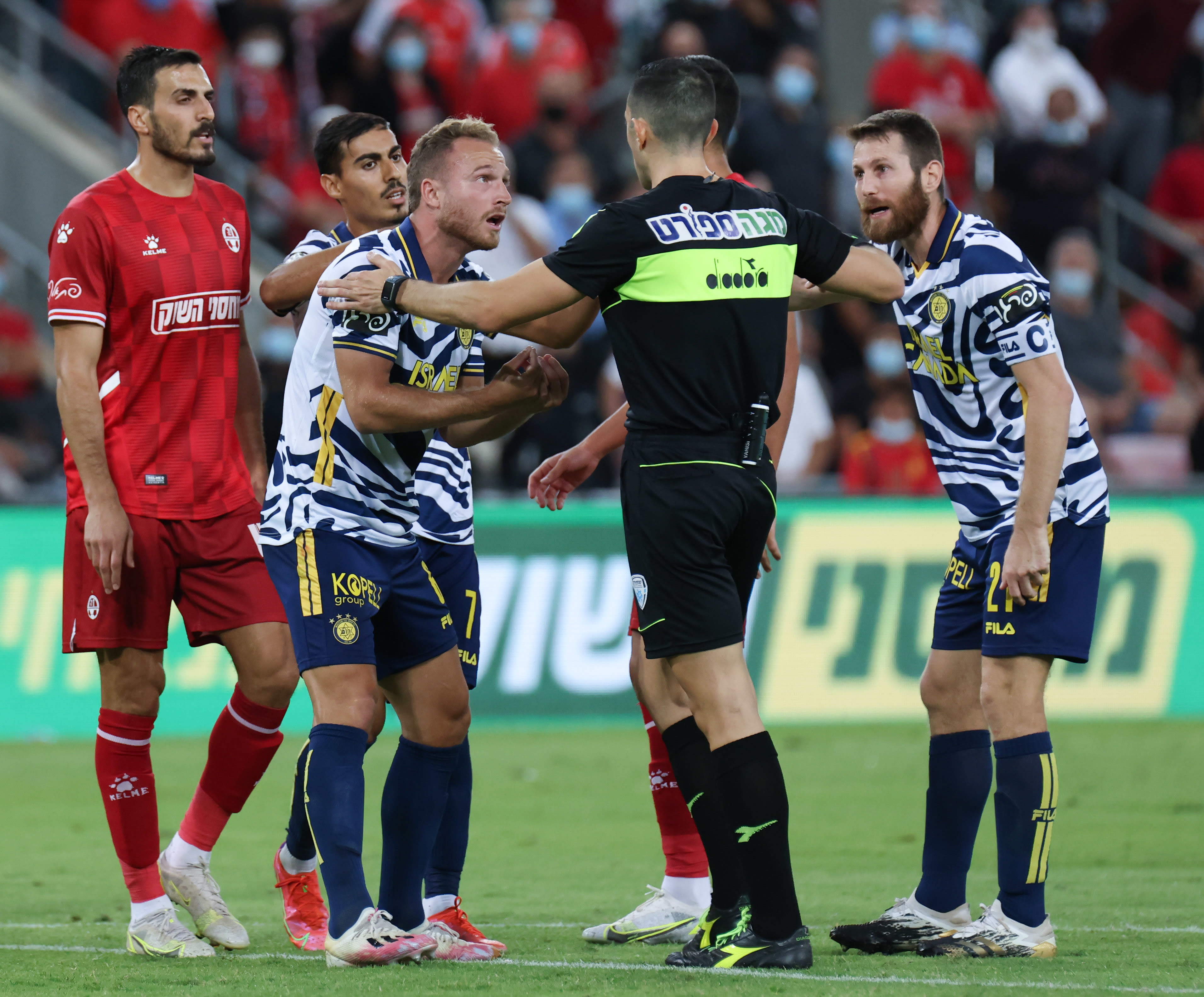 דן גלזר שחקן מכבי תל אביב, שרן ייני עם השופט אביעד שילוח