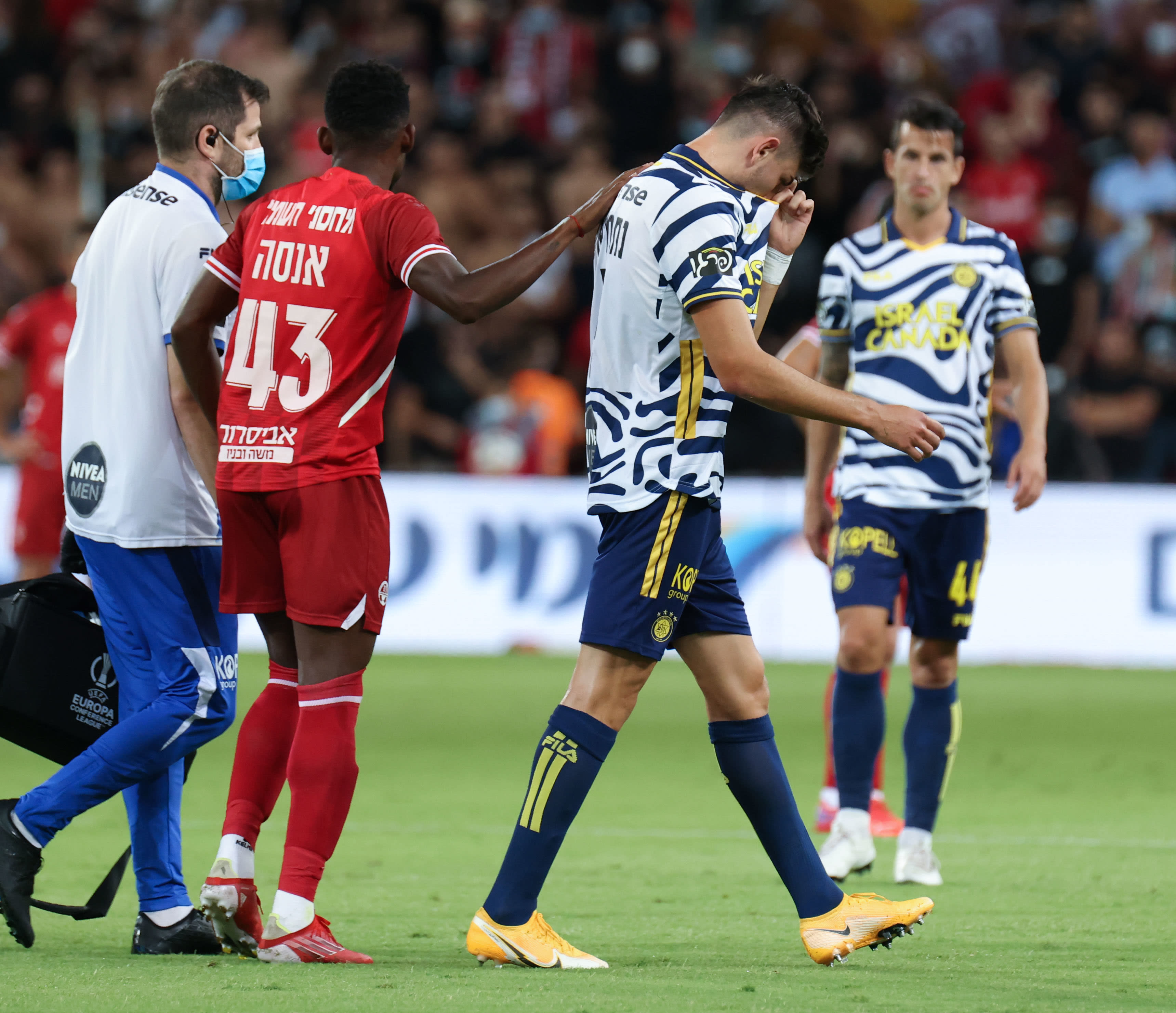 שחקן מכבי תל אביב עידן נחמיאס יורד מהמגרש כשהוא בוכה, מול שחקן הפועל באר שבע יוג'ין אנסה