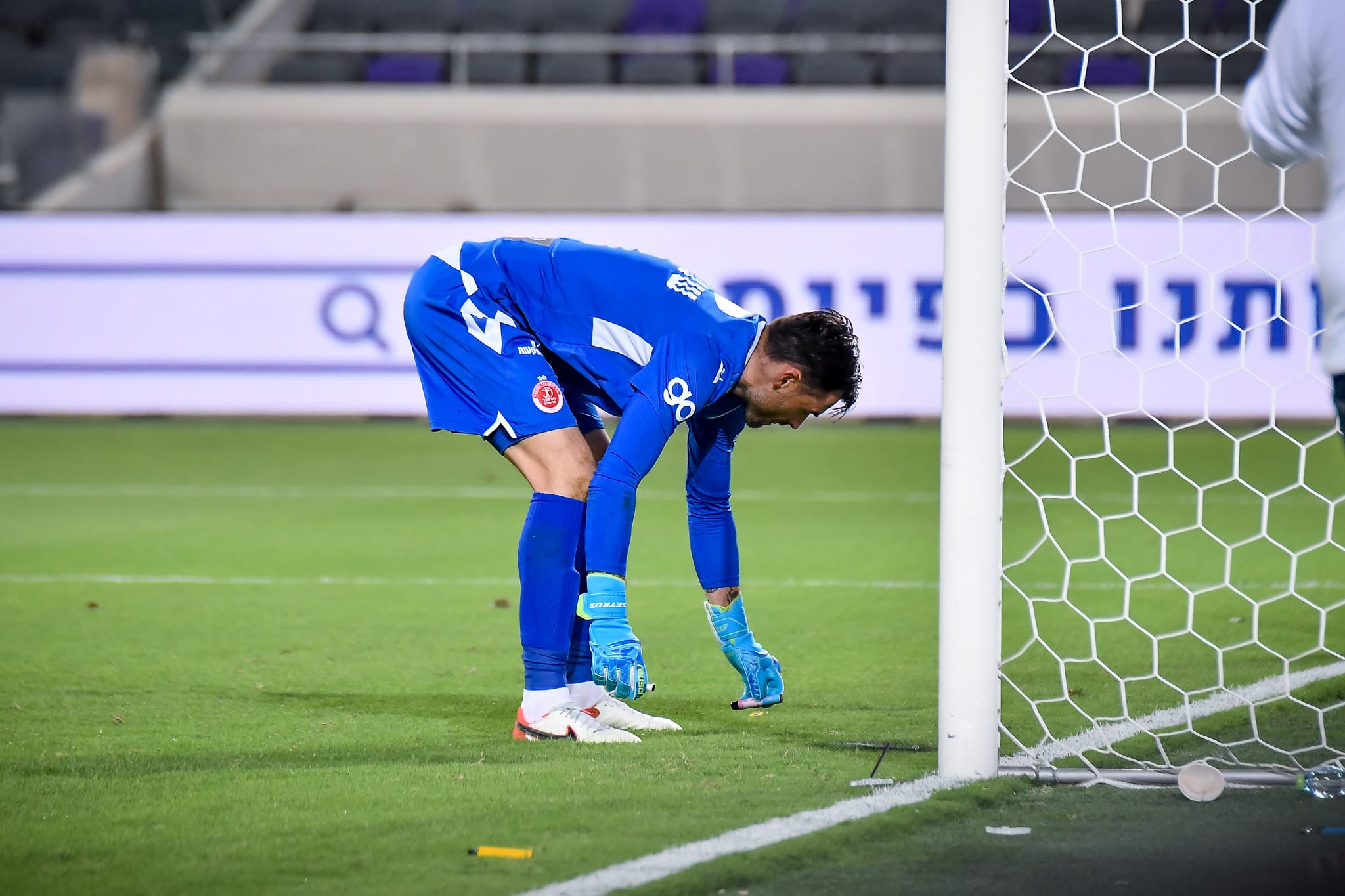 ארנסטס שטקוס שוער הפועל תל אביב מוציא חפצים שנזרקו למגרש