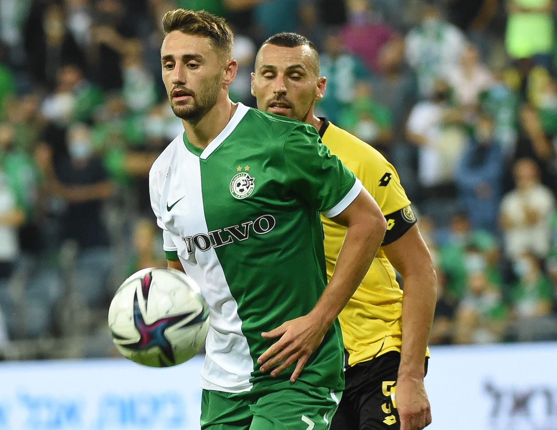 שחקן מכבי חיפה, עומר אצילי, ליד שחקן מכבי נתניה שיר צדק