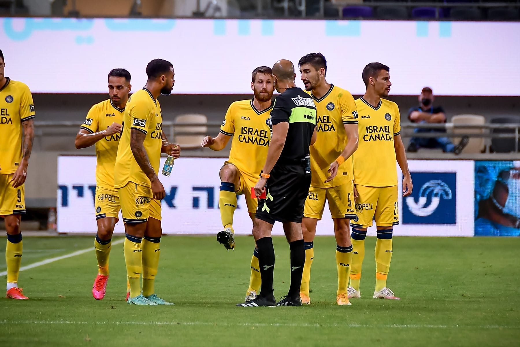 שרן ייני שחקן מכבי תל אביב עם השופט דניאל בר נתן