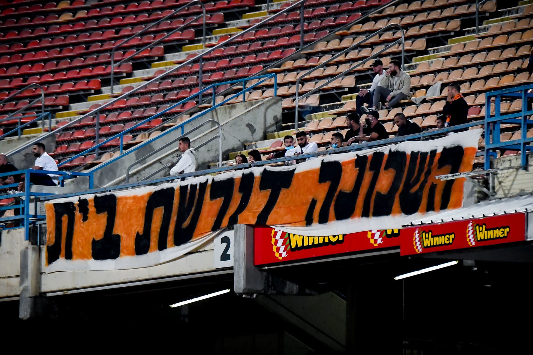 אוהדי בני יהודה עם שלט מחאה: השכונה דורשת בית