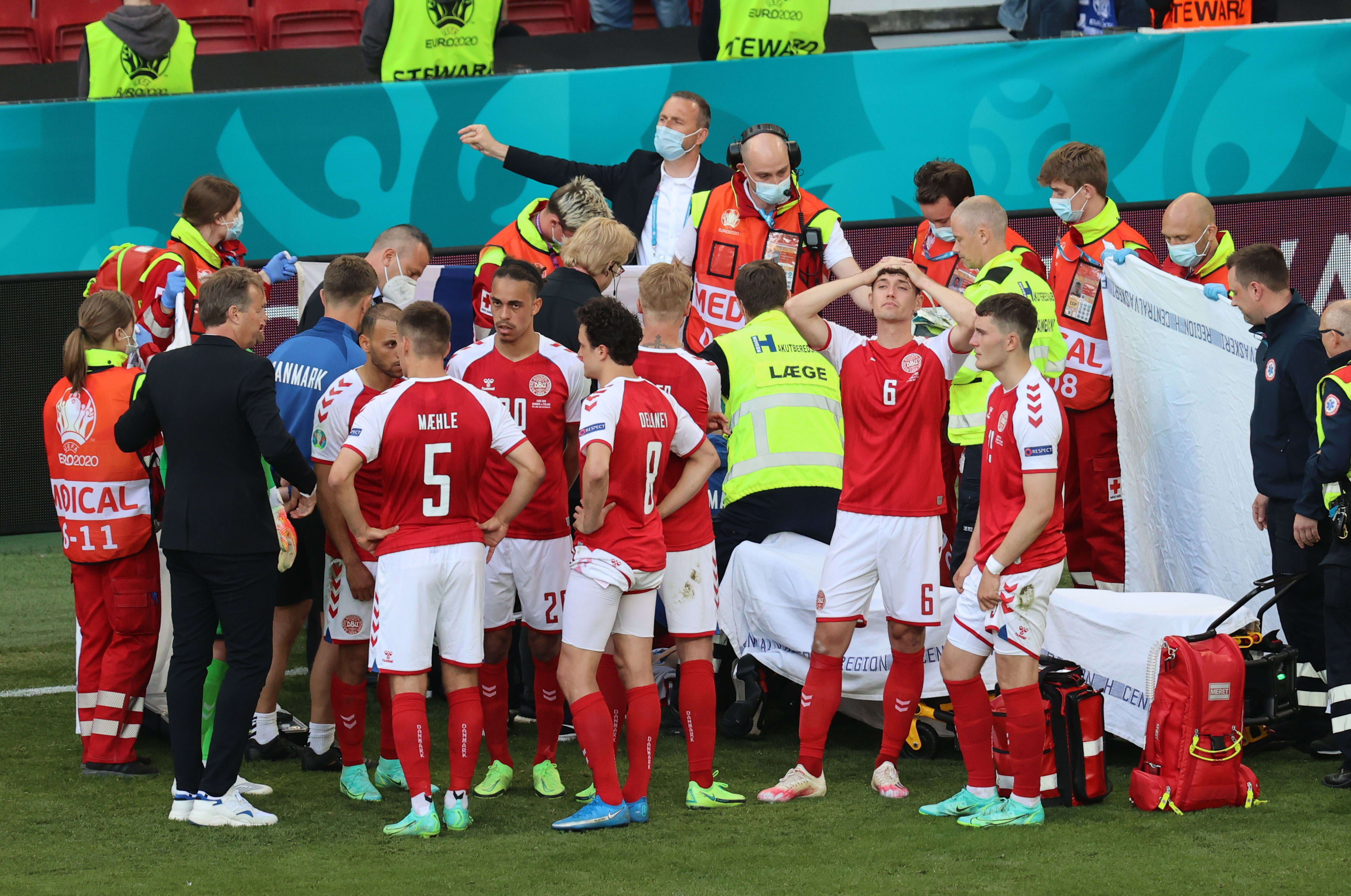 שחקני נבחרת דנמרק ואנשי הצוות הרפואי מקיפים את כריסטיאן אריקסן