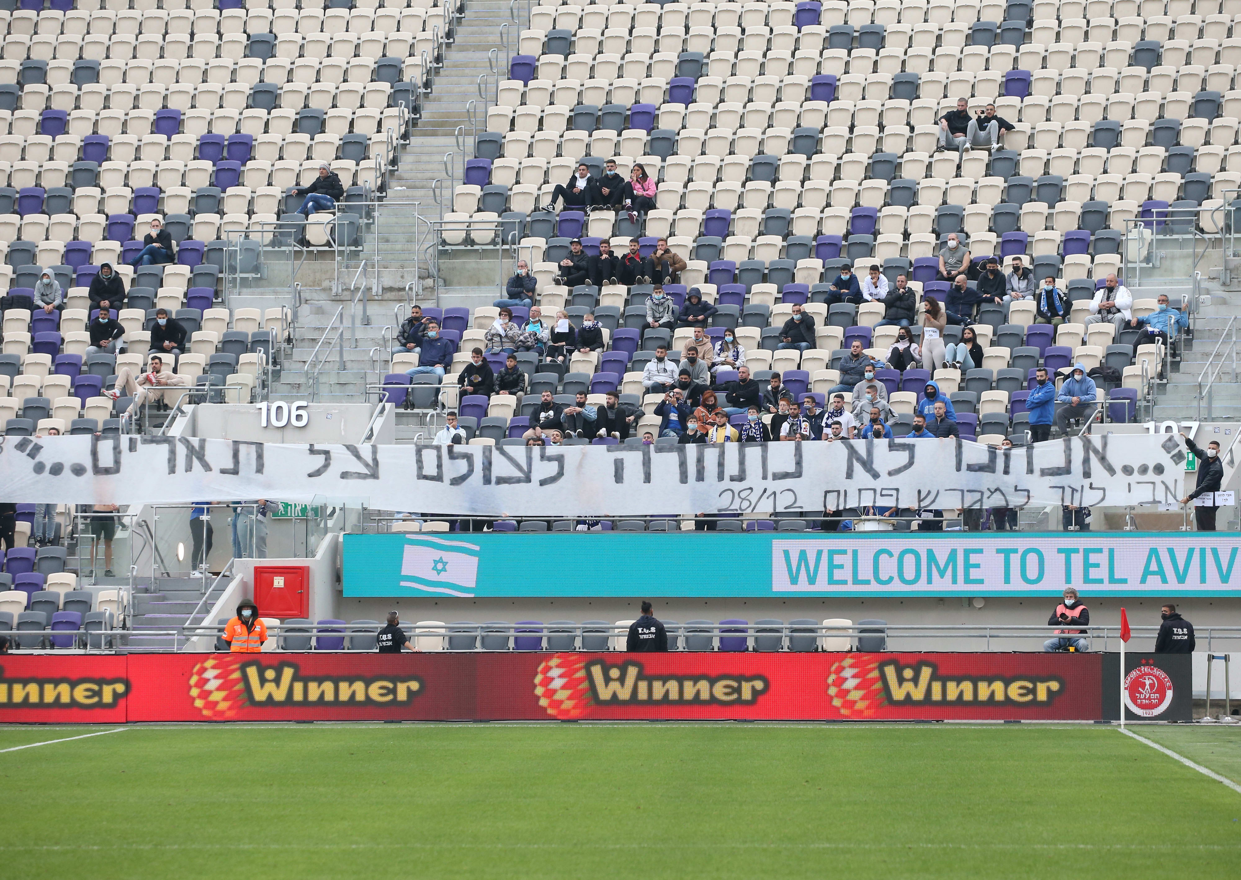 שלט של אוהדי מכבי פתח תקוה עם ציטוט של אבי לוזון