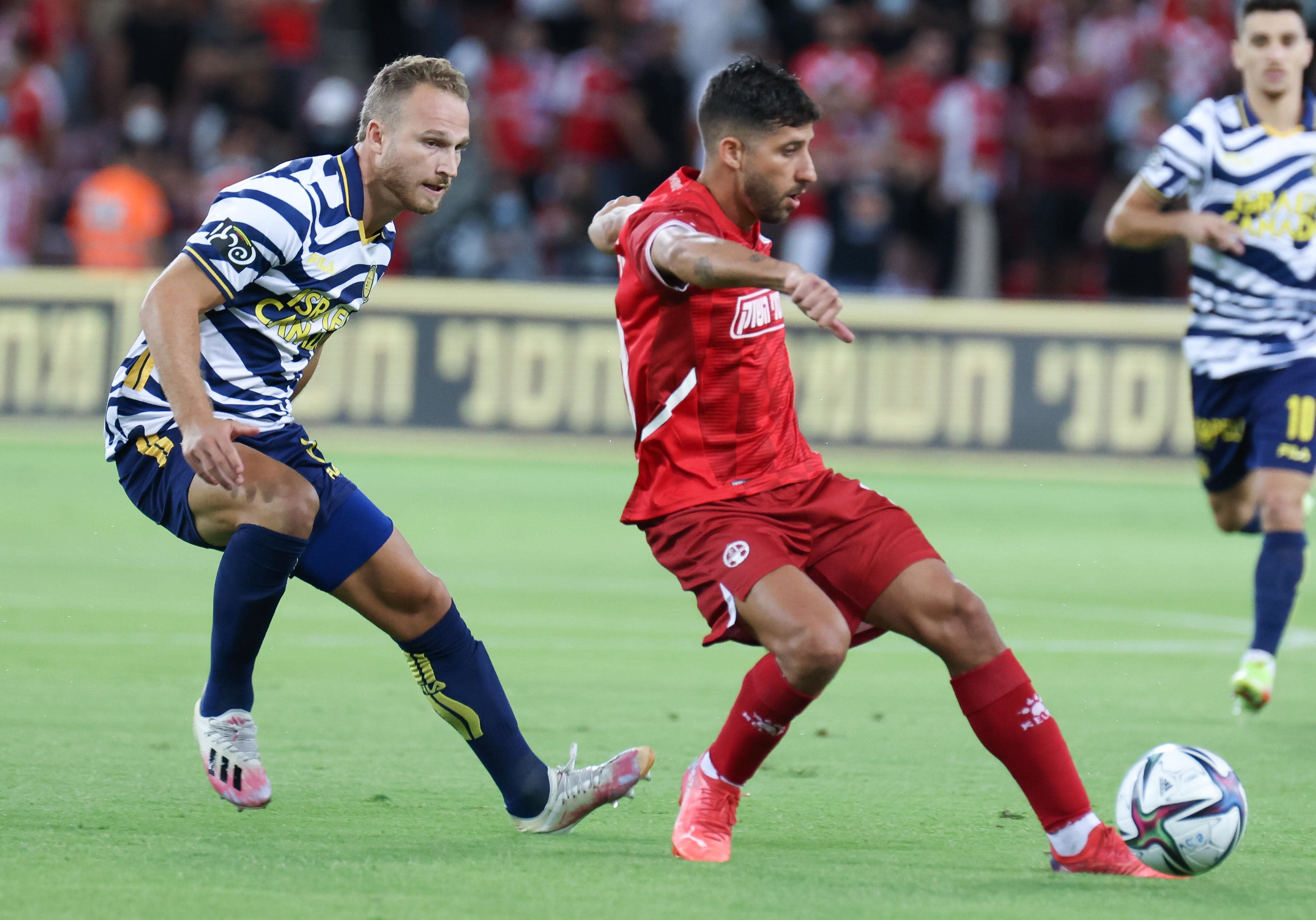 דור מיכה שחקן הפועל באר שבע לפני דן גלזר שחקן מכבי תל אביב