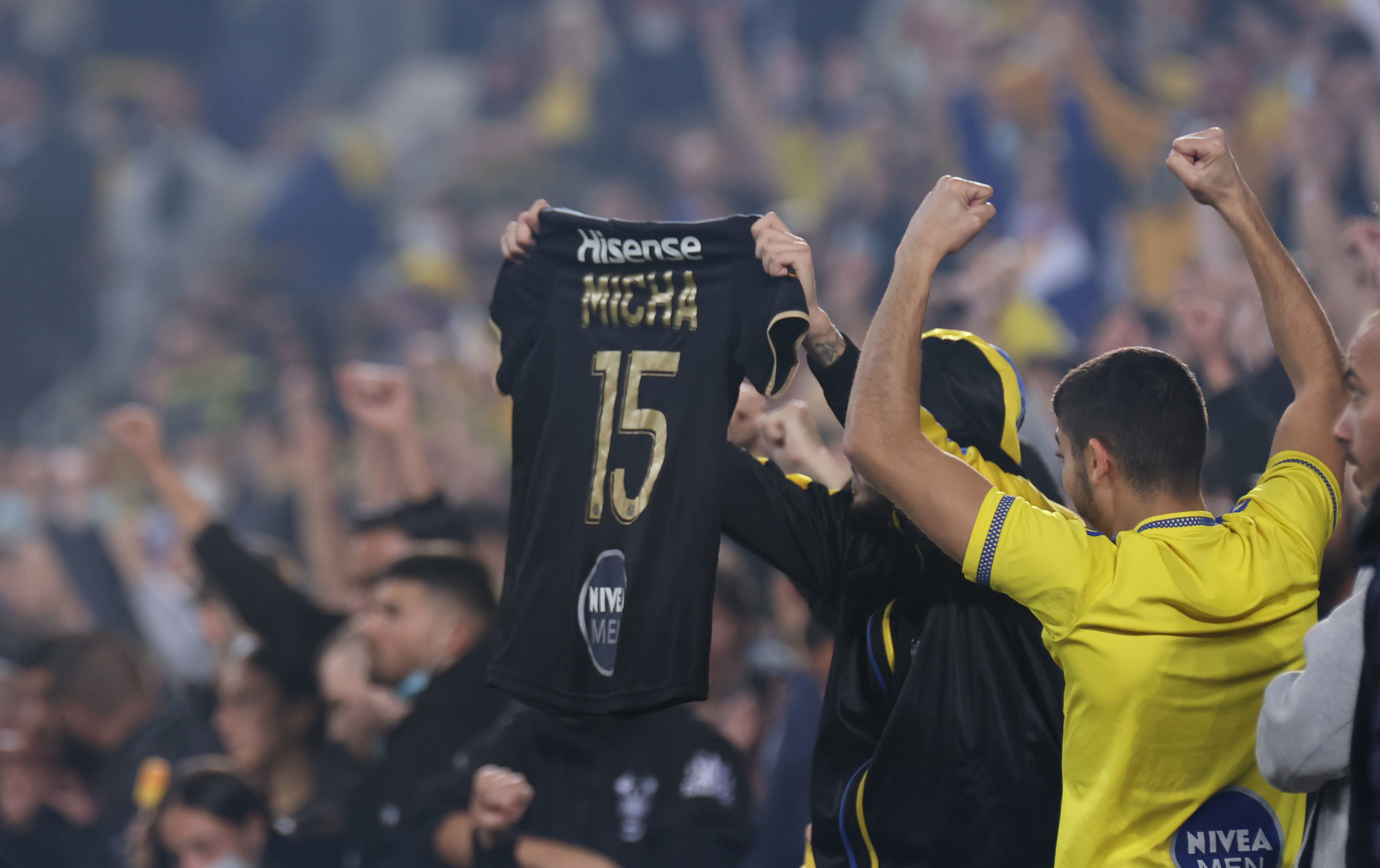 אוהדי מכבי תל אביב מניפים חולצה של דור מיכה