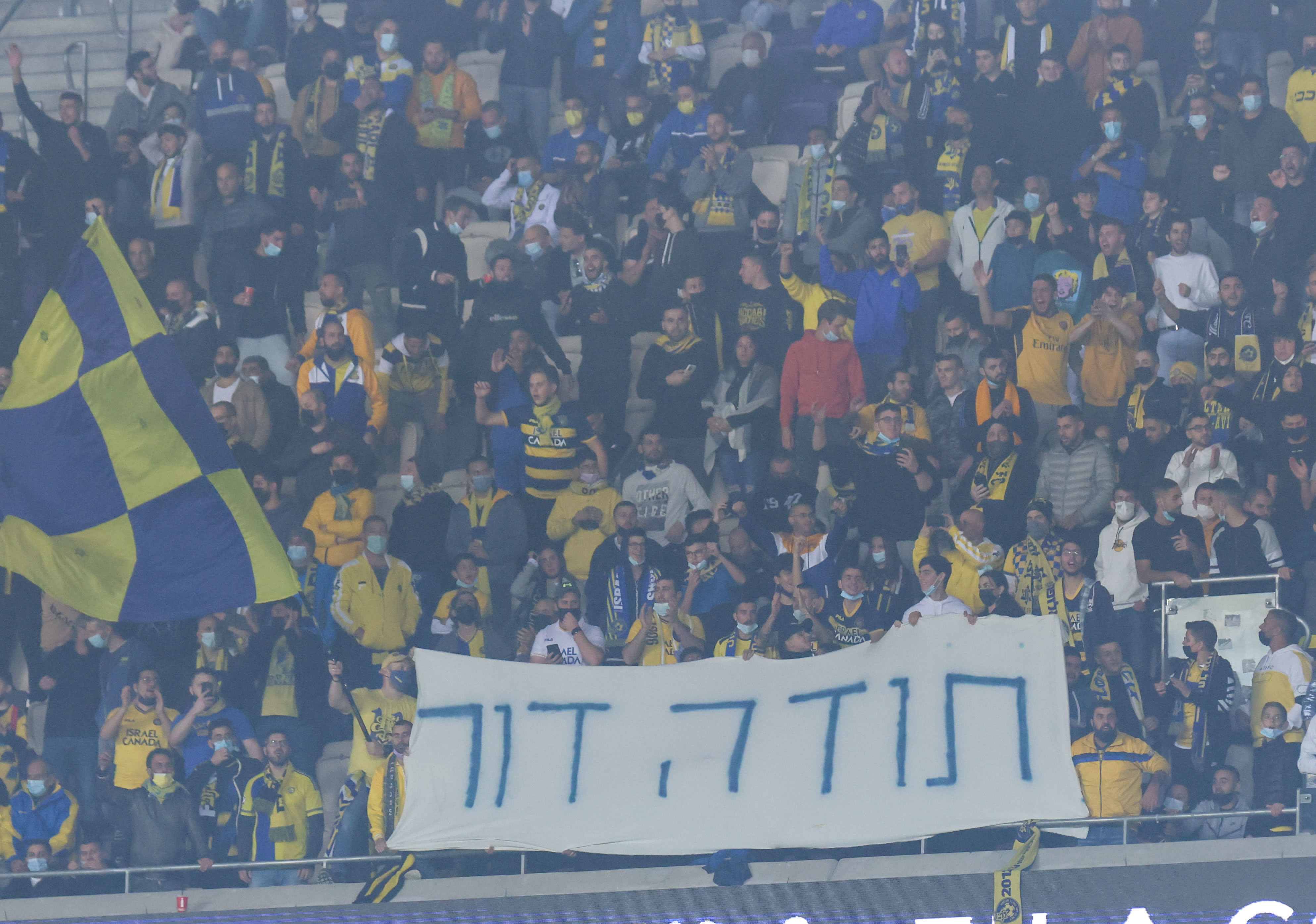 אוהדי מכבי תל אביב עם שלט לשחקן הקבוצה לשעבר דור מיכה