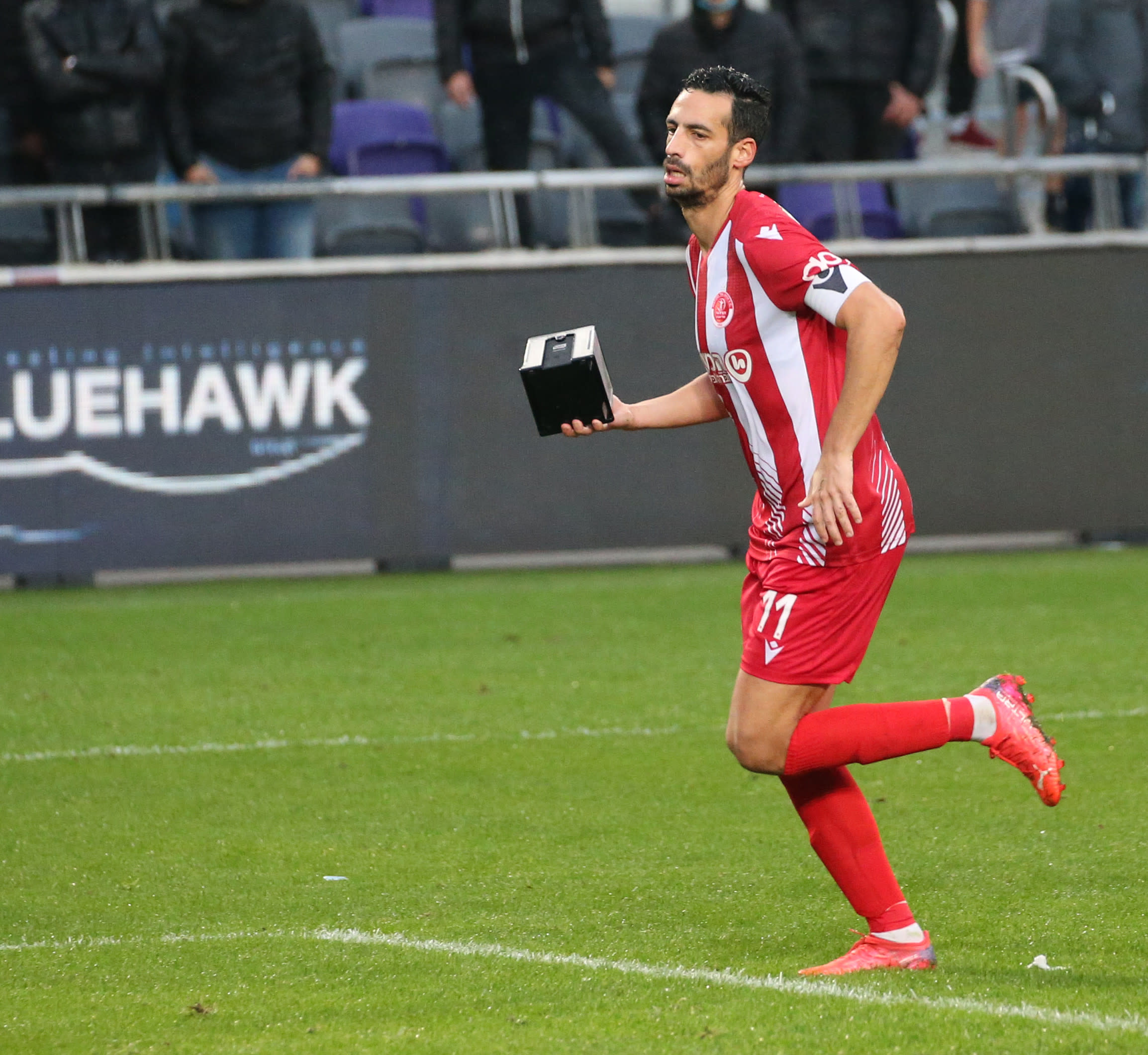 דן איינבינדר שחקן הפועל תל אביב עם מתקן מפיות שנזרק אל הדשא