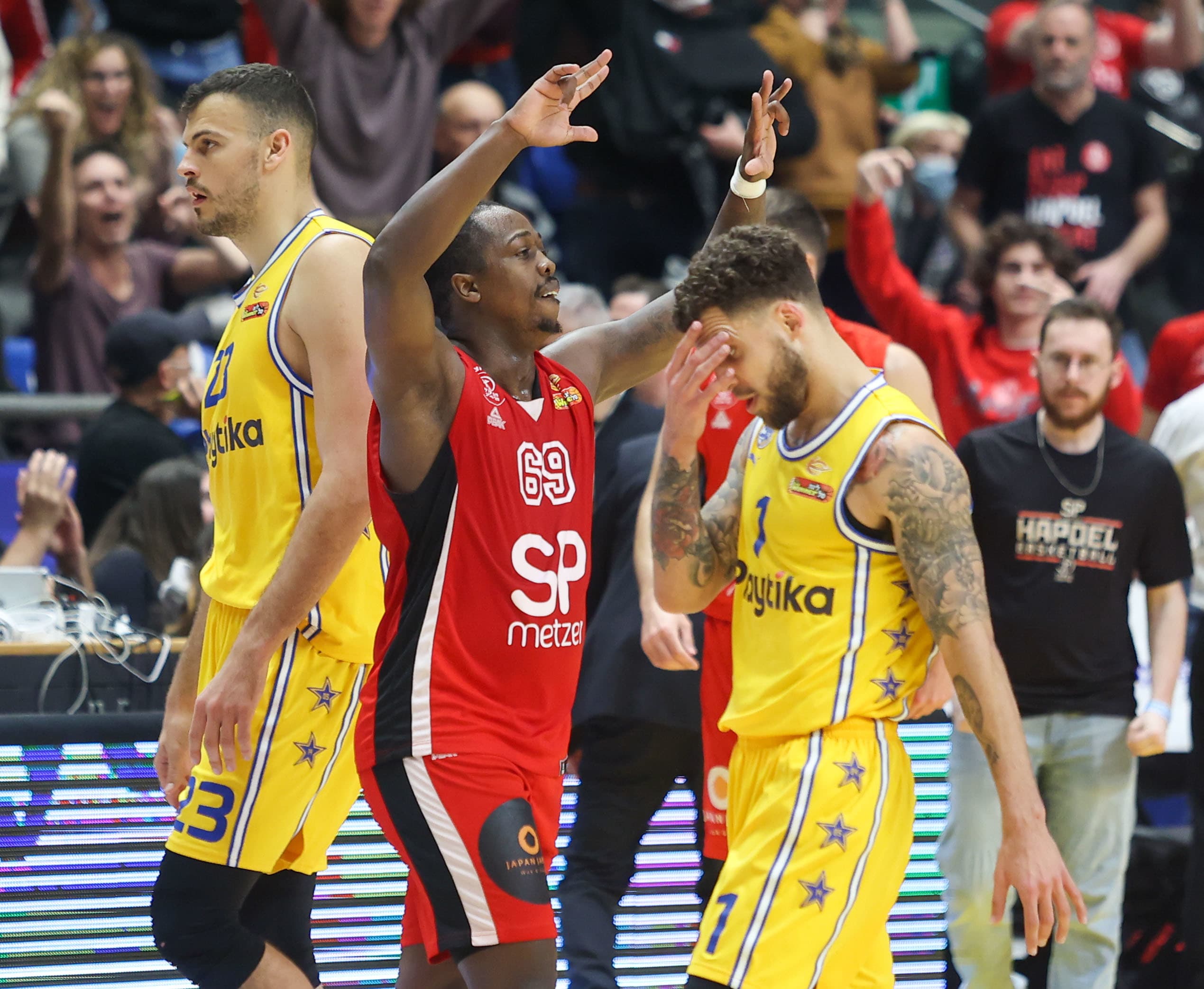 שחקן הפועל תל אביב ג'ייקובן בראון על רקע שחקן מכבי תל אביב סקוטי ווילבקין