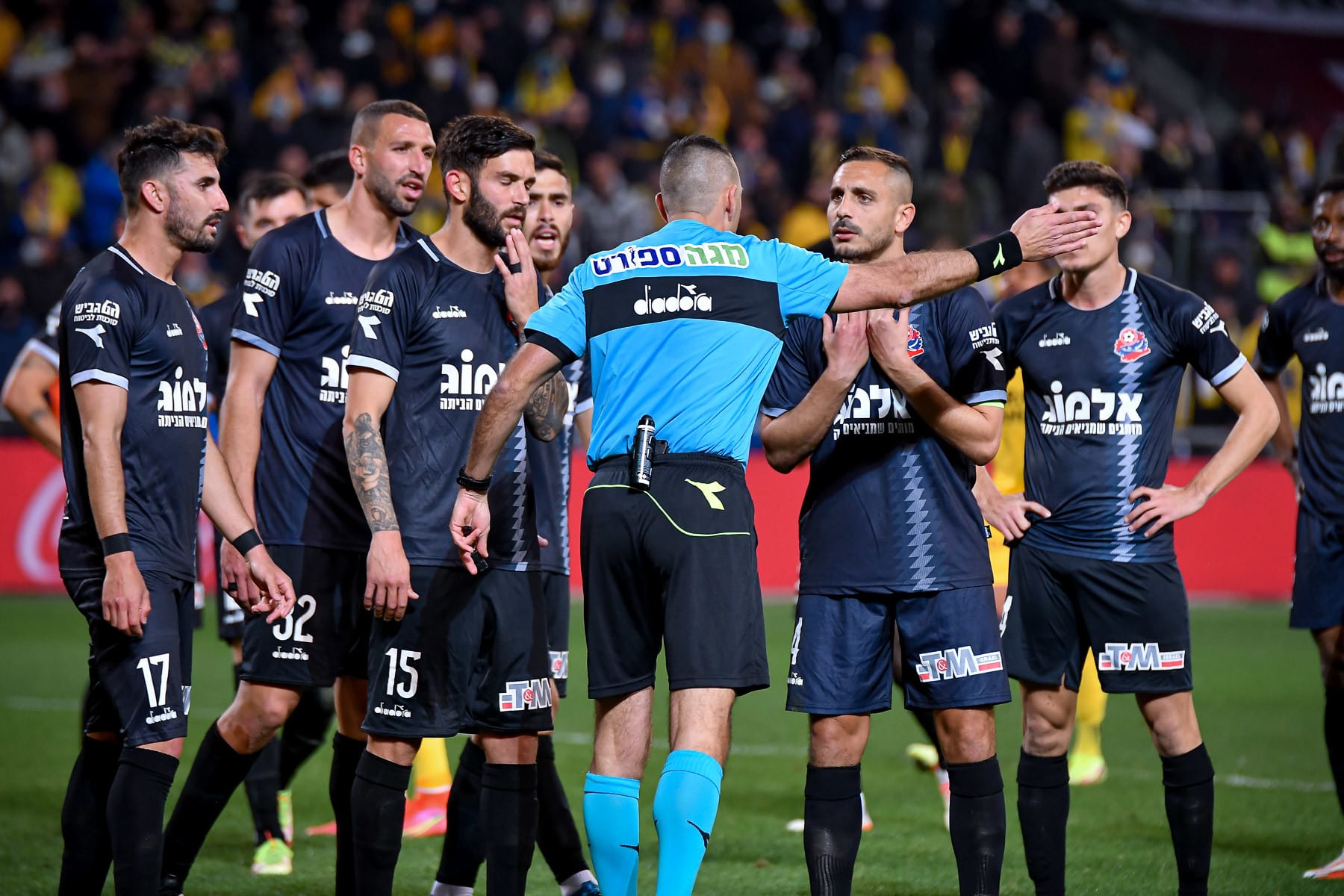 שחקני הפועל חיפה עם השופט רועי ריינשרייבר