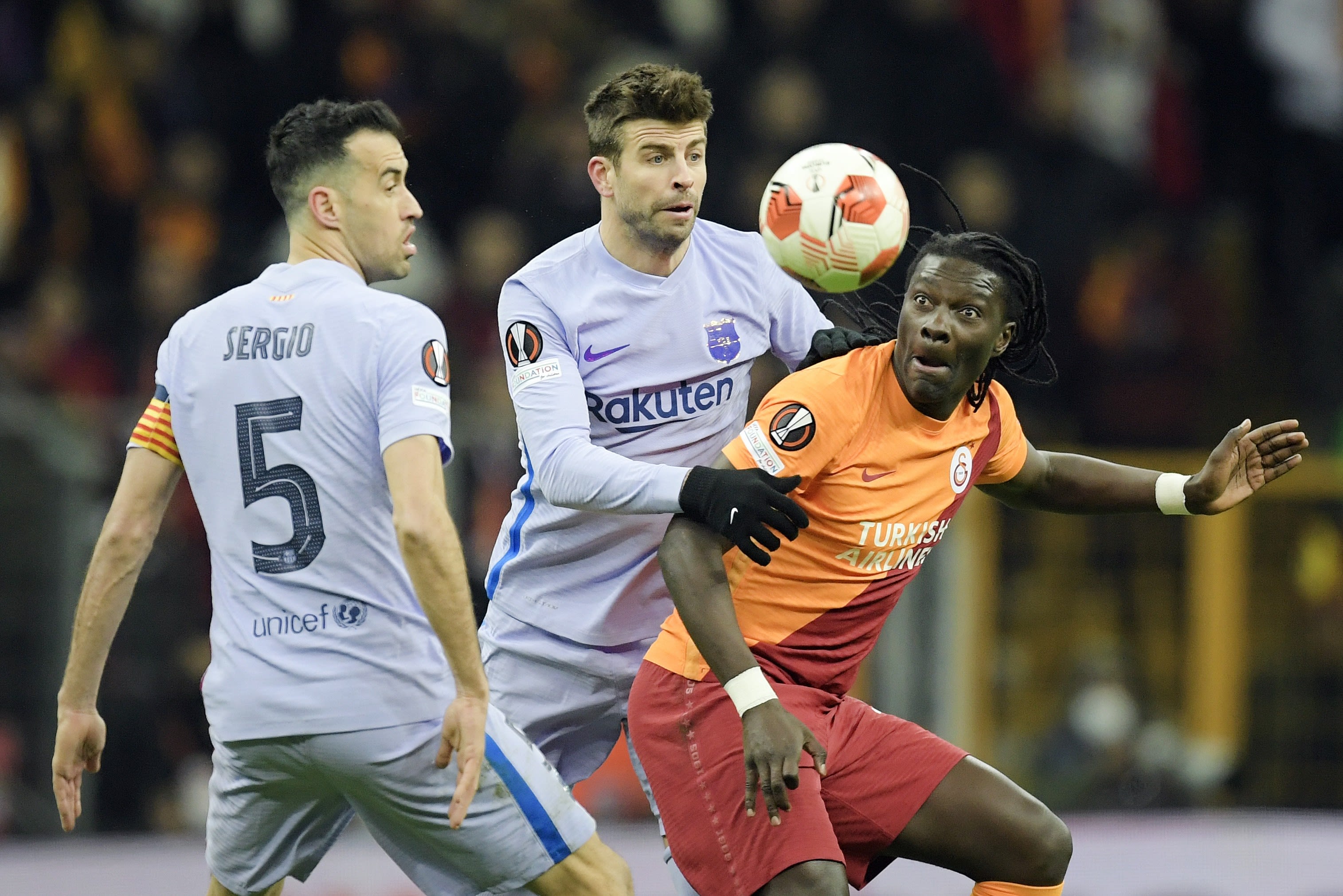 שחקני ברצלונה ג'רארד פיקה, סרחיו בוסקטס מול שחקן  גלאטסראיי באפטימבי גומיס