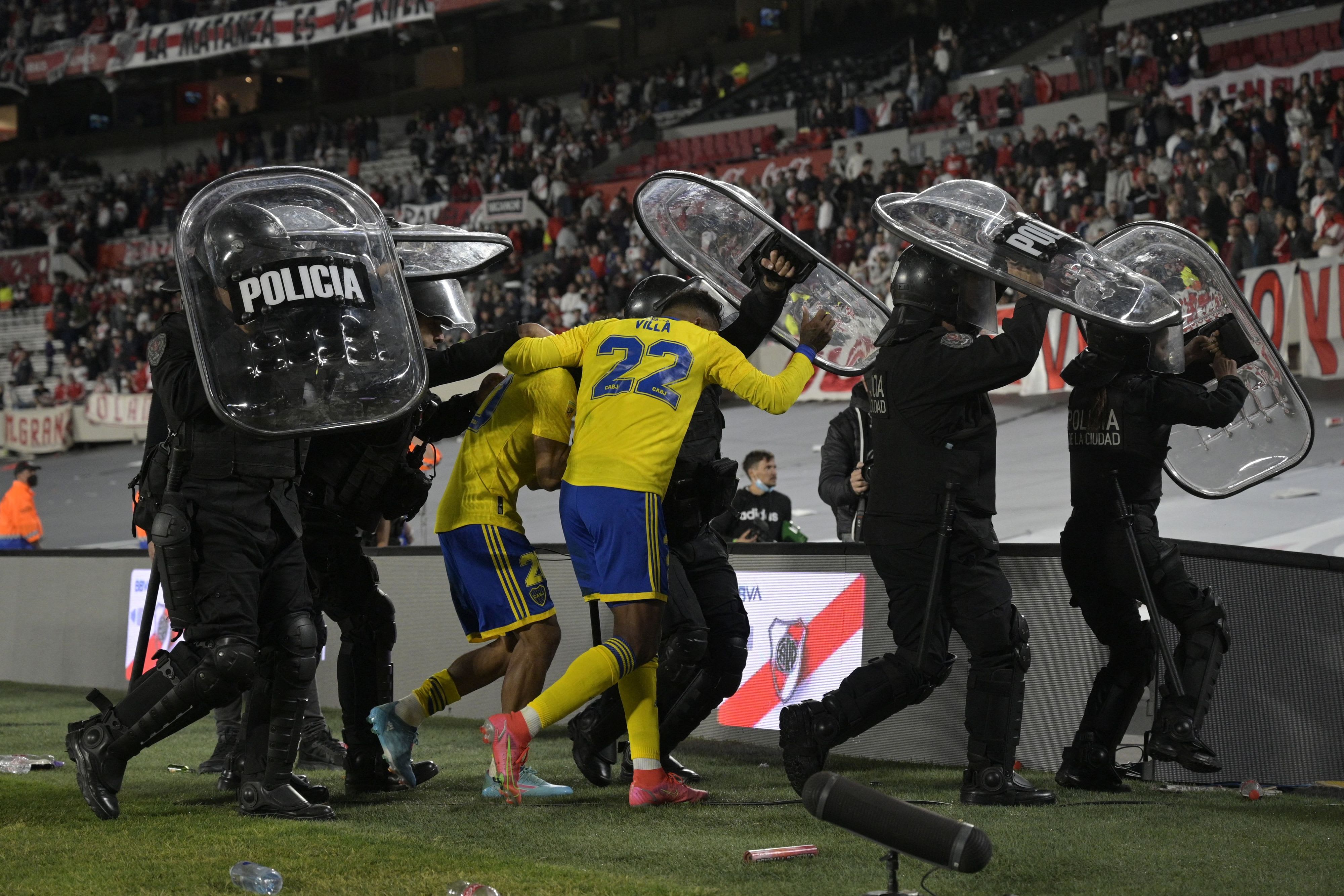 שחקני בוקה ג'וניורס יורדים מהמשחק נגד ריבר פלייט בליווי משטרתי