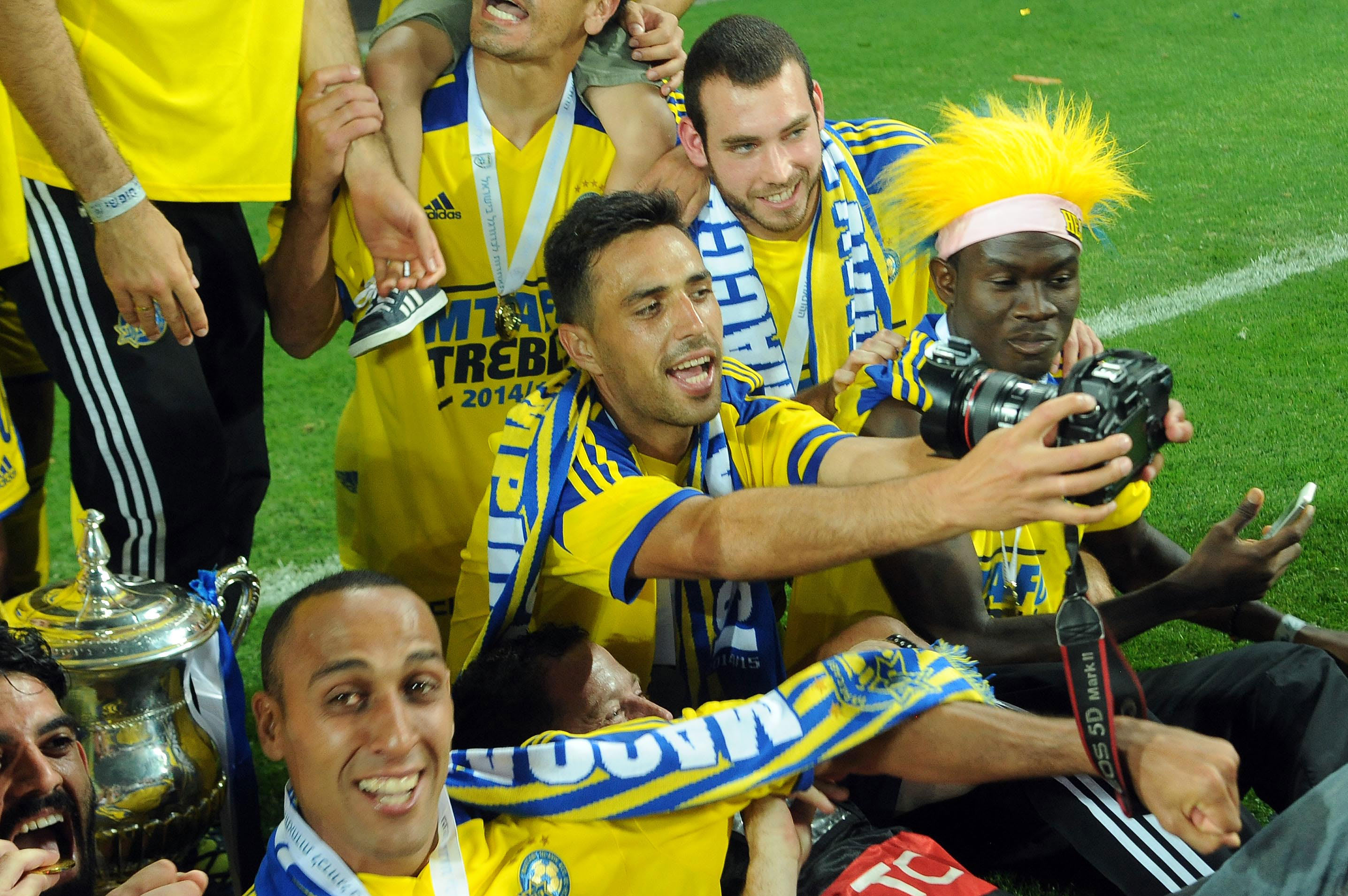 ערן זהבי שחקן מכבי תל אביב (אמצע) עם מהראן ראדי, נוסא איגייבור