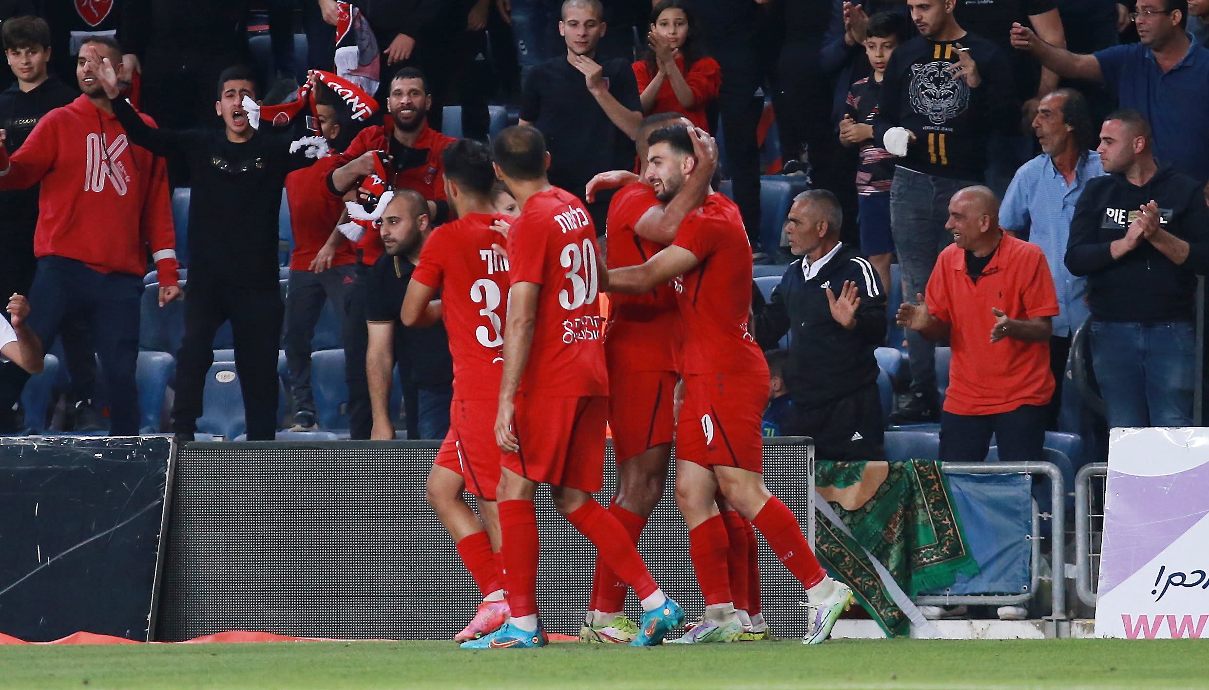 שחקני מ.ס. כפר קאסם חוגגים עם הישאם לאיוס (מימין)