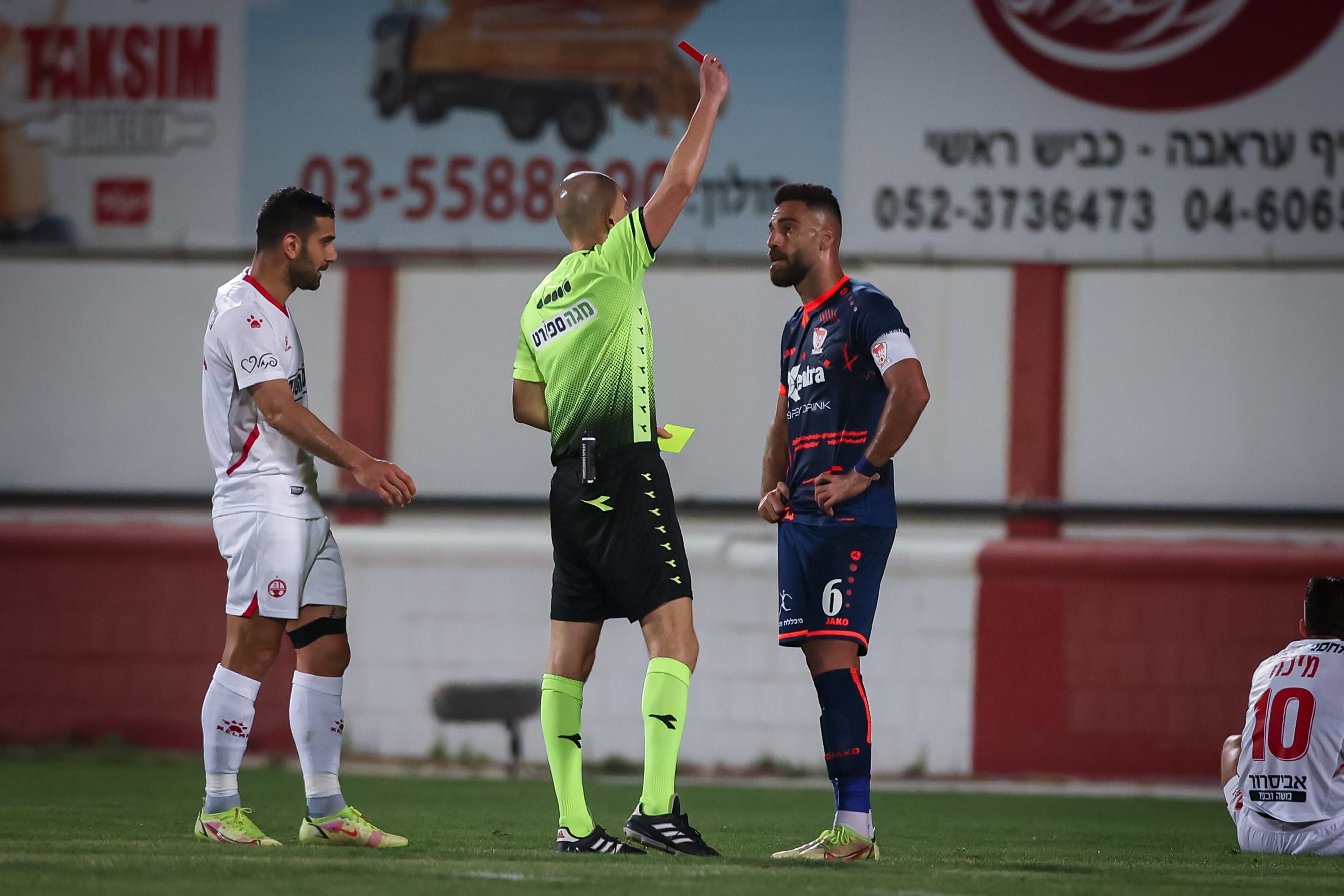 שופט הכדורגל עידן לייבה מראה את הכרטיס האדום לשחקן בני סכנין איהאב גנאים