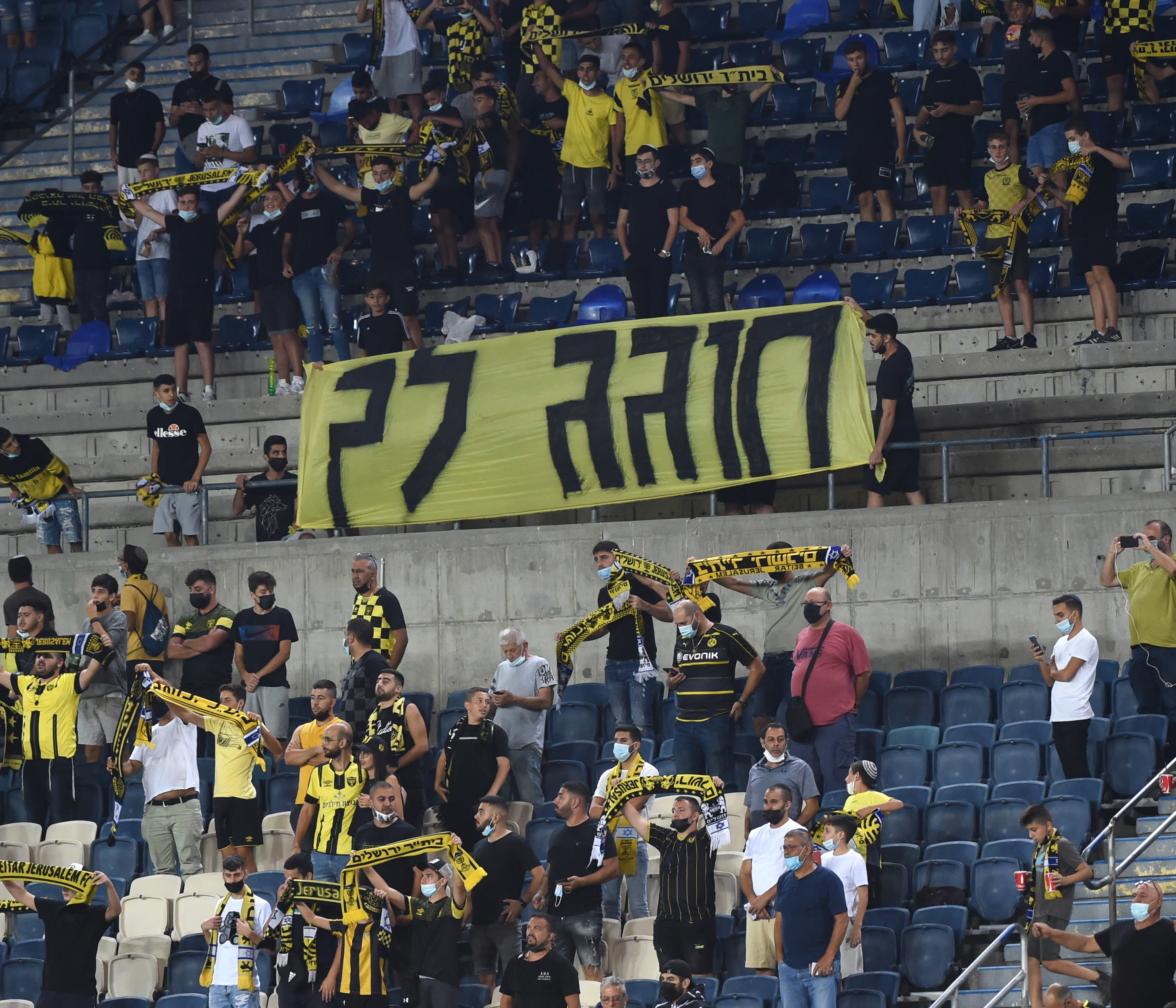 אוהדי בית"ר ירושלים עם שלט נגד הבעלים משה חוגג