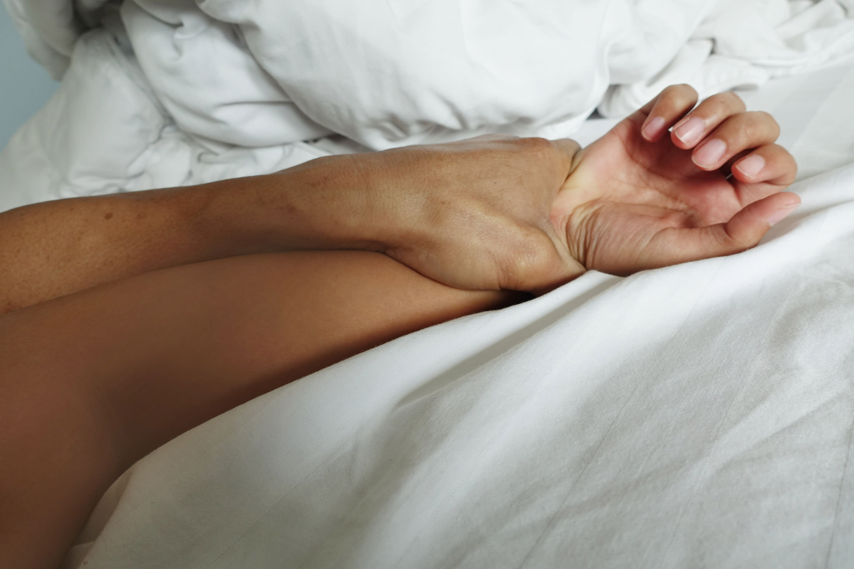 יד של גבר ויד של אישה במיטה