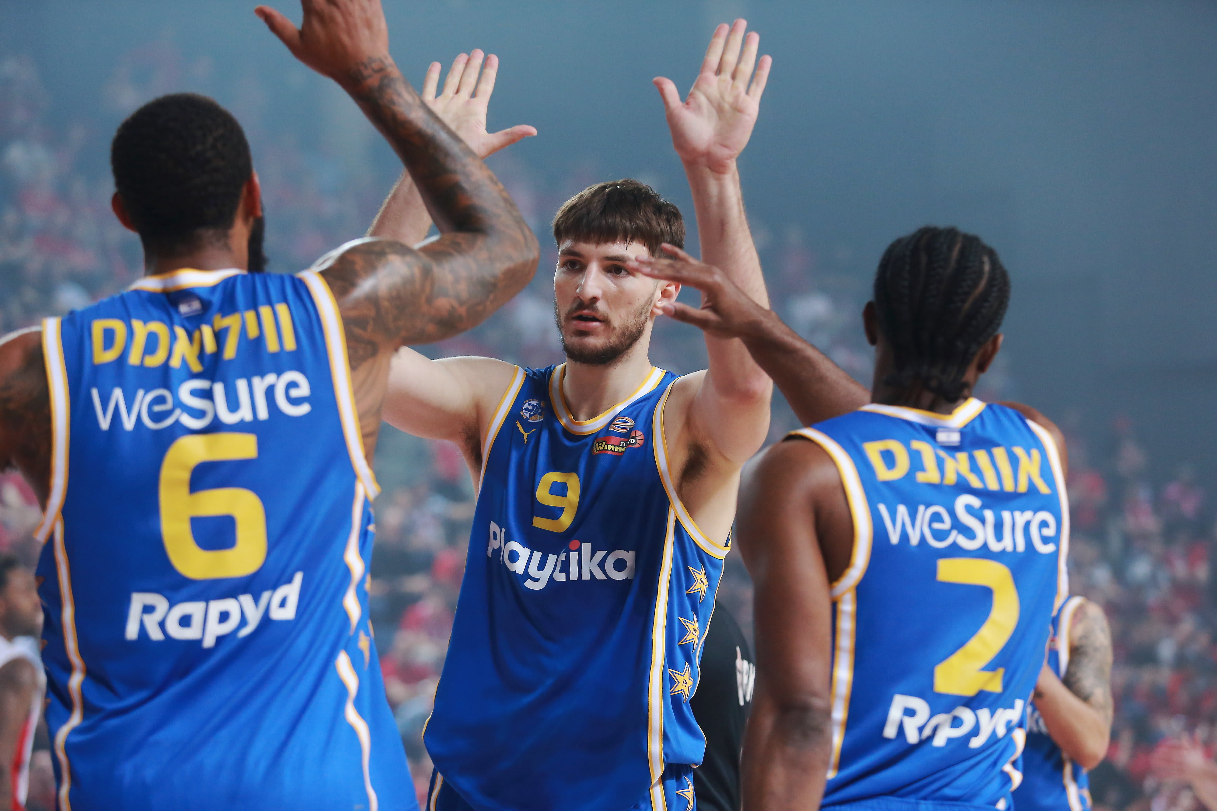 שחקן מכבי תל אביב רומן סורקין עם דרק וויליאמס, קינן אוואנס