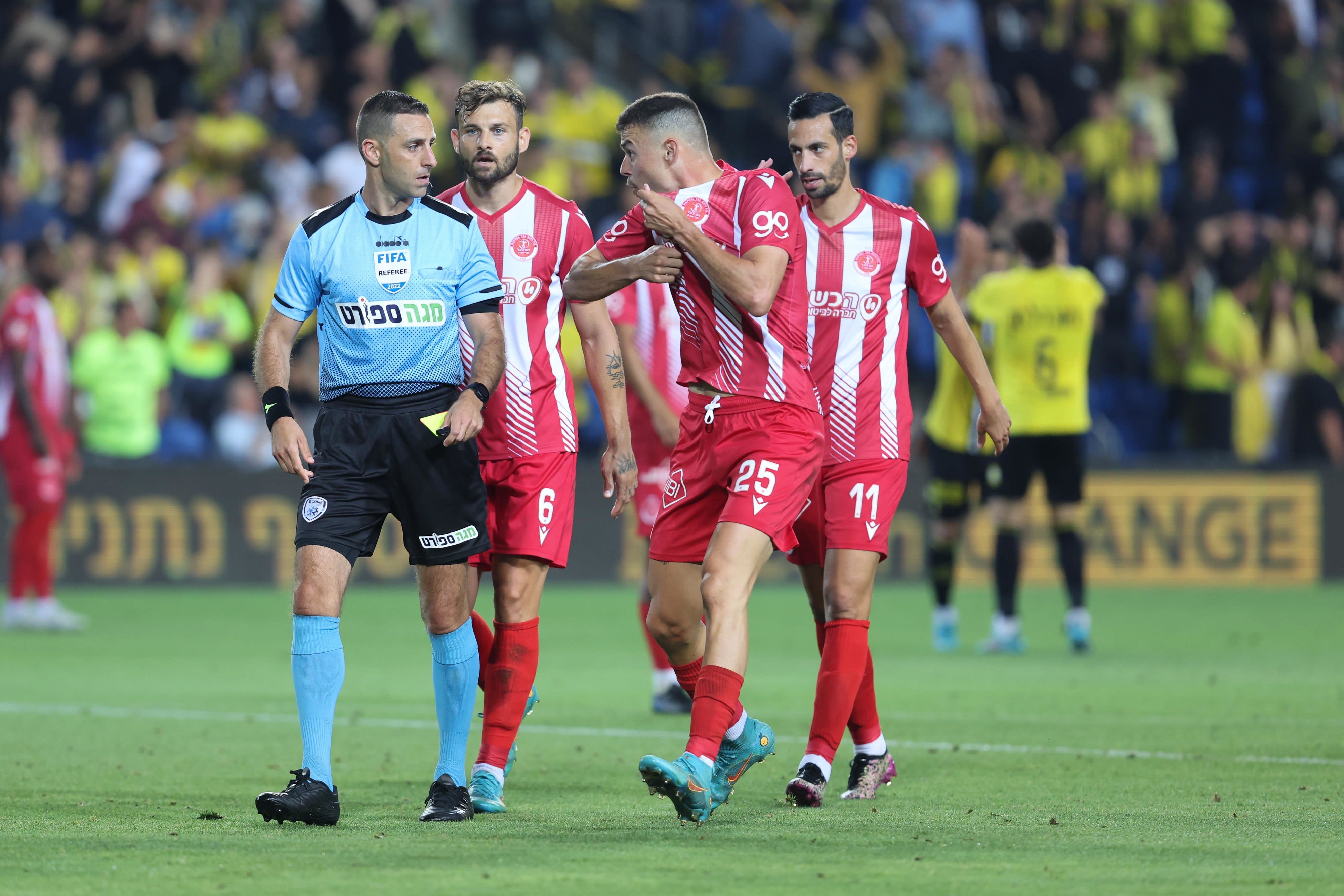 סתיו למקין שחקן הפועל תל אביב עם השופט רועי ריינשרייבר