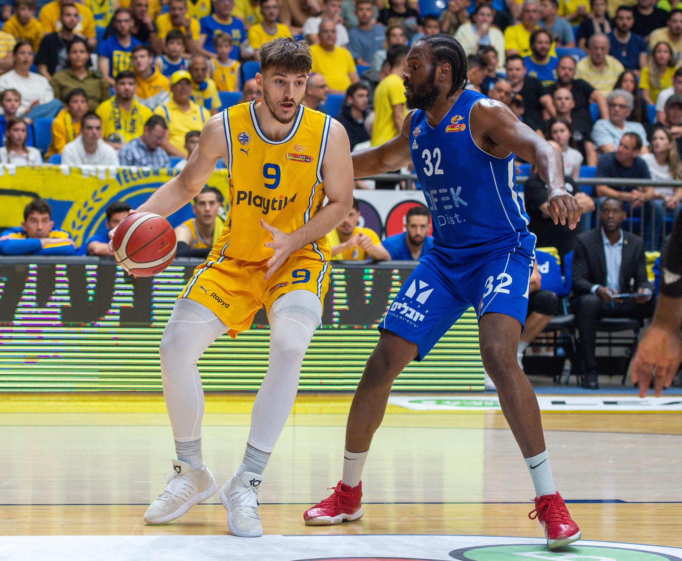 שחקן בני הרצליה צ'ינאנו אונואקו שומר על שחקן מכבי תל אביב רומן סורקין