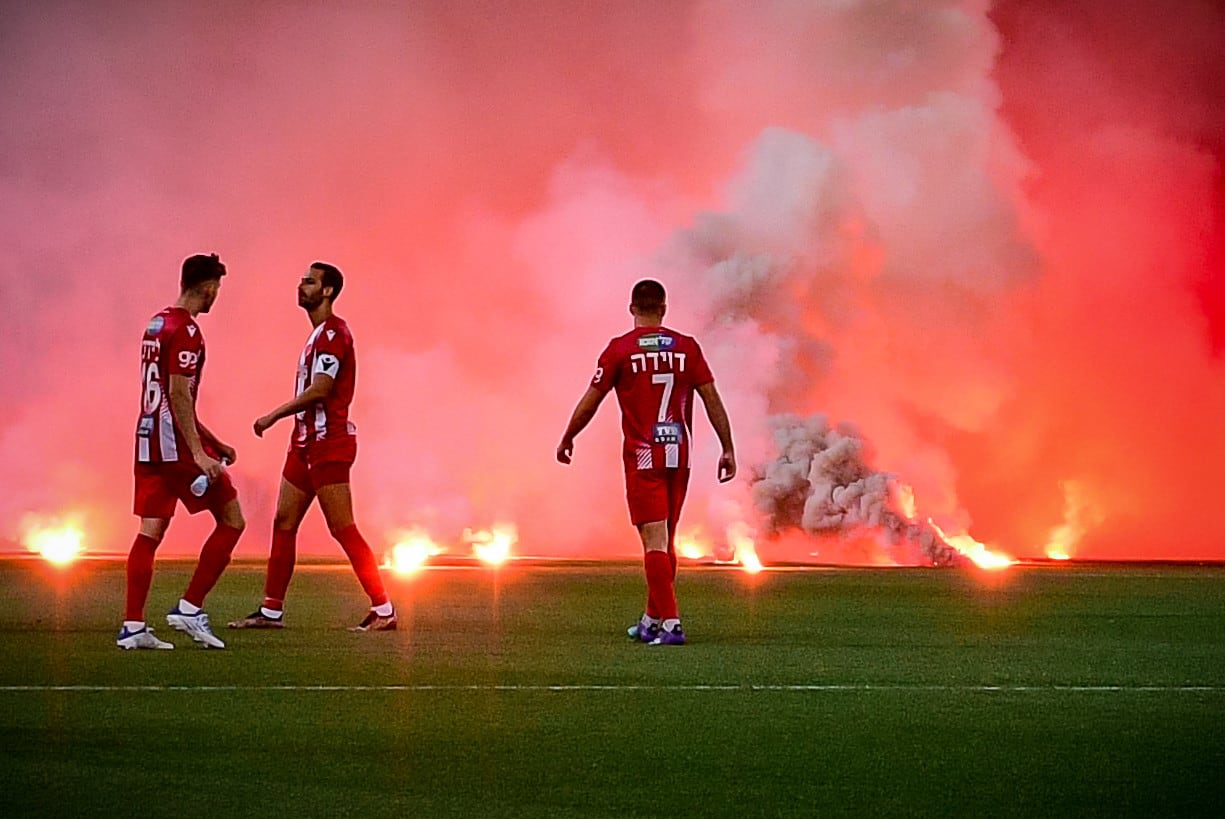 שחקני הפועל תל אביב על רקע האבוקות