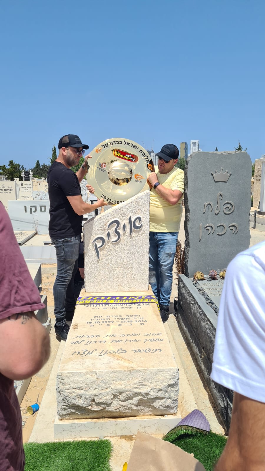 אוהדי הפועל חולון עם צלחת האליפות בבית העלמין