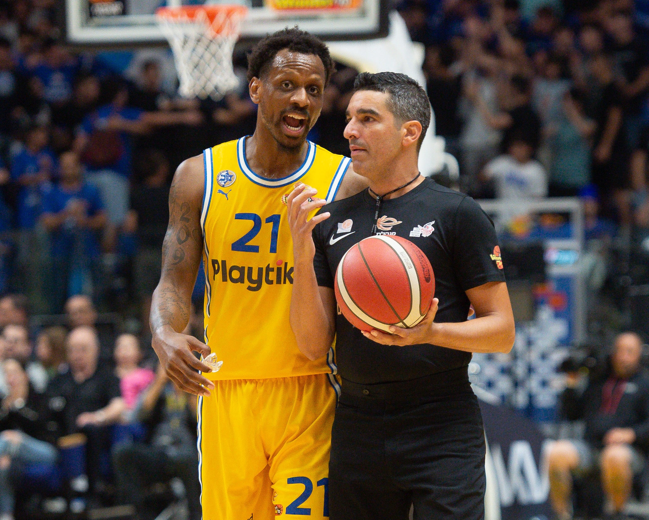 שחקן מכבי תל אביב ג'יימס נאנלי עם שופט הכדורסל עמית בלק