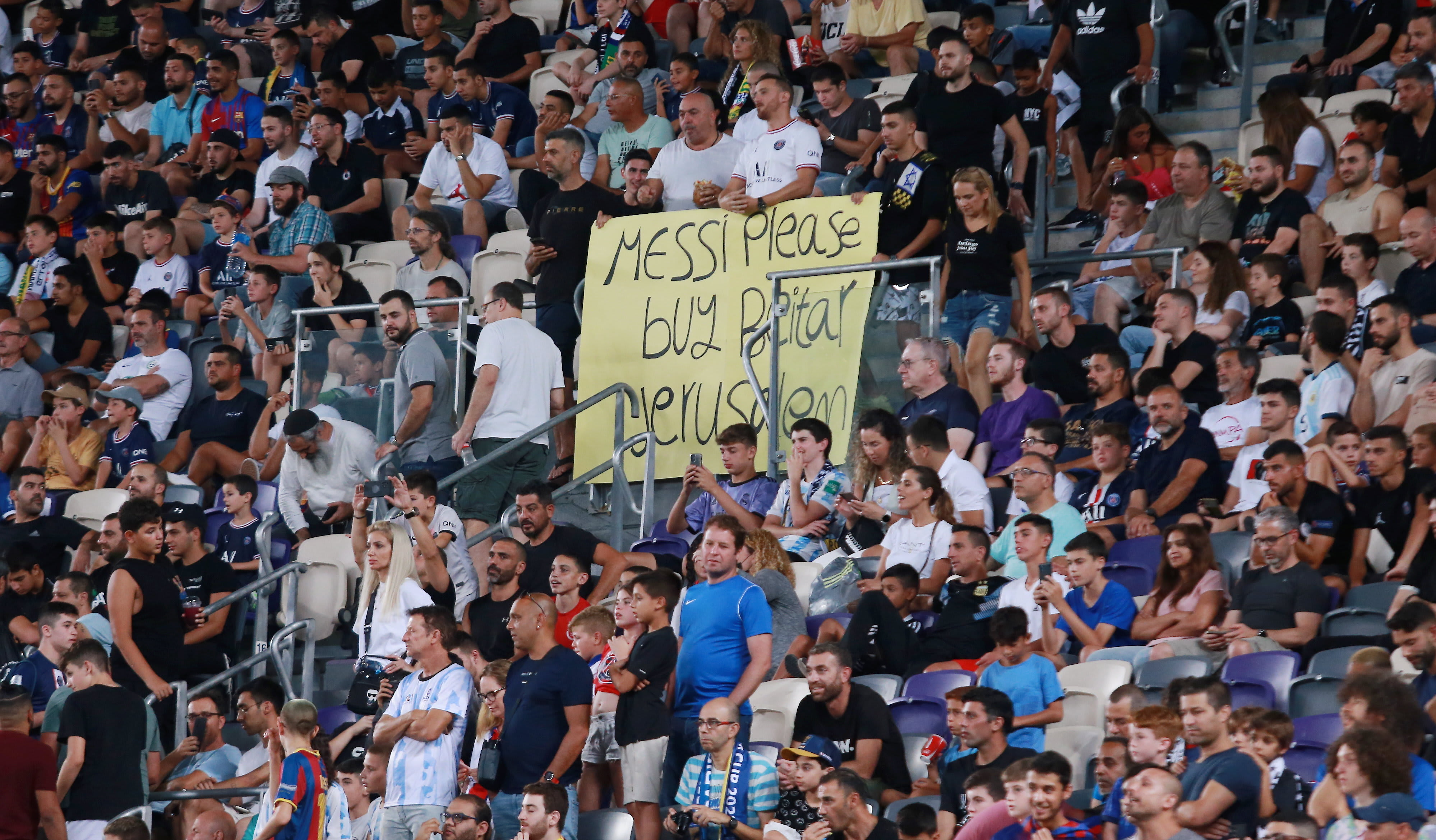 שלט של אוהדים הקורא אל ליאונל מסי, שחקן פריז סן ז'רמן, לקנות את בית