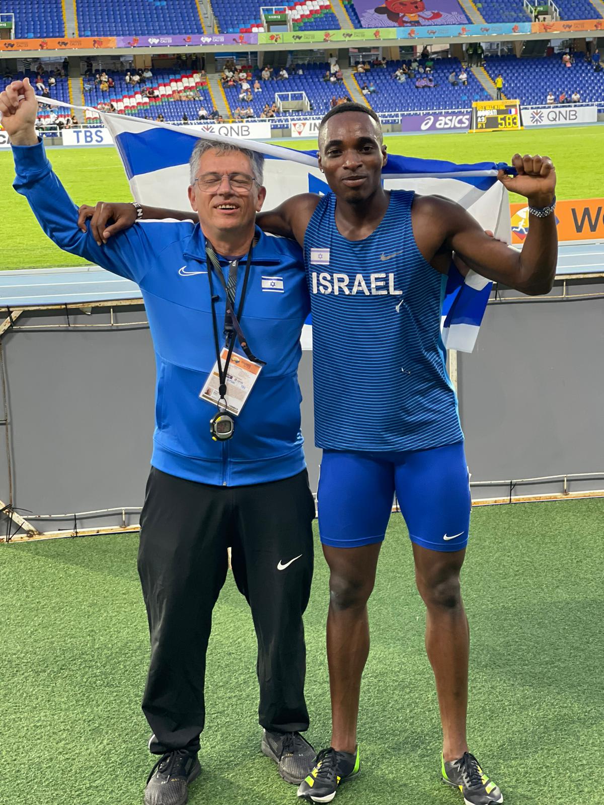 האצן הישראלי בלסינג אפריפה אחרי שניפץ את שיא התחרות בגמר ריצת ה-200 מטר עד גיל 20. לצידו מאמנו איגור בלון