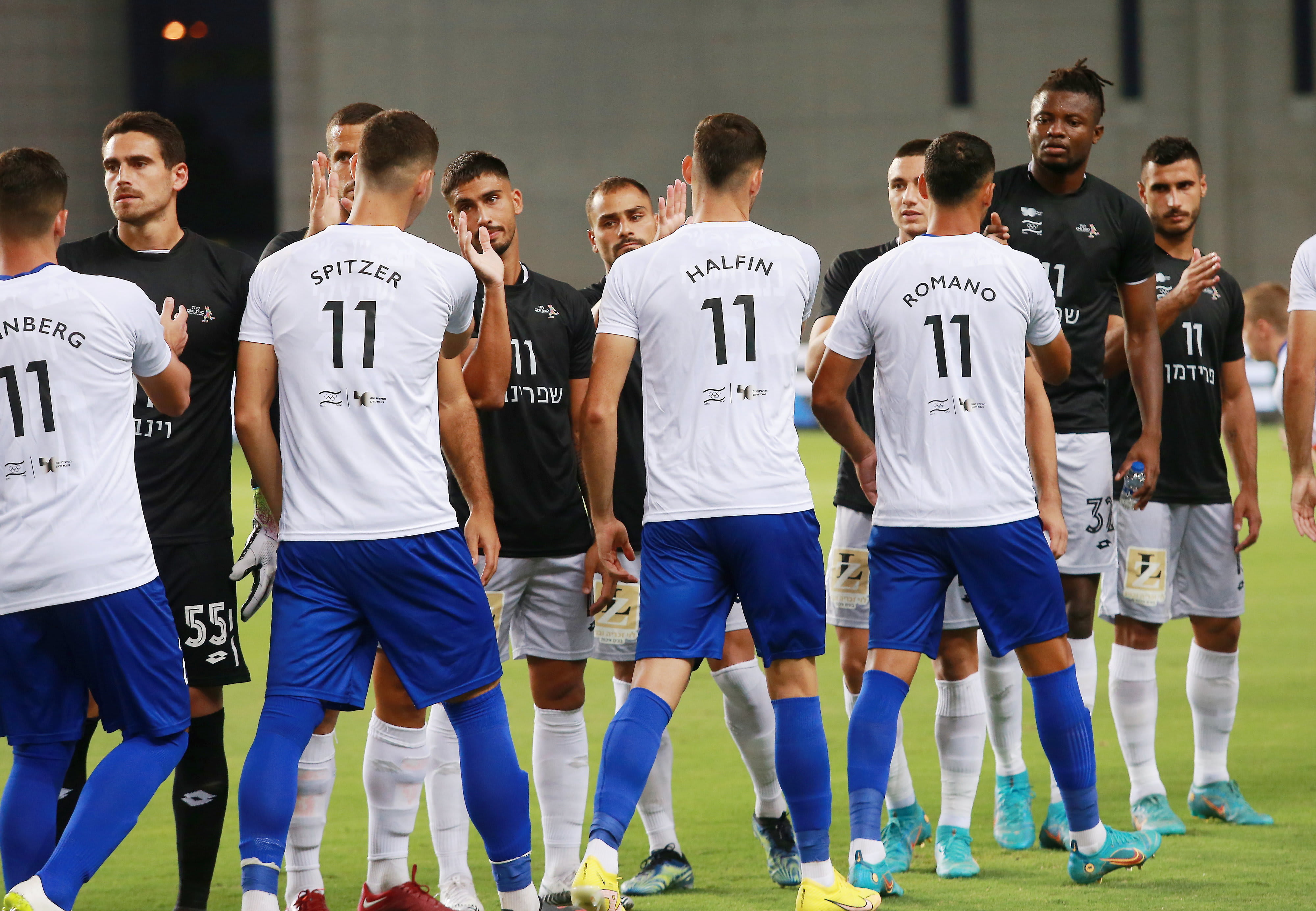 שחקני הפועל חדרה ושחקני עירוני קרית שמונה עם המספר 11 על החולצות ושמותיהם של י"א חללי מינכן