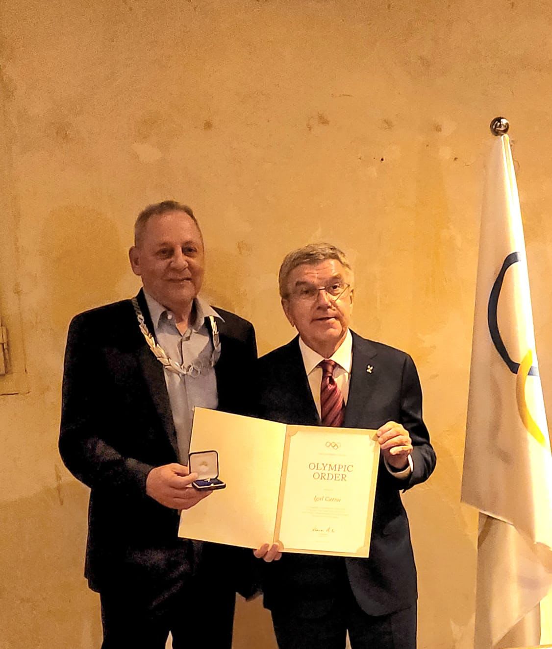 נשיא הוועד האולימפי הבינלאומי תומאס באך מעניק את עיטור הכבוד ליו"ר הוועד האולימפי הקודם יגאל כרמי