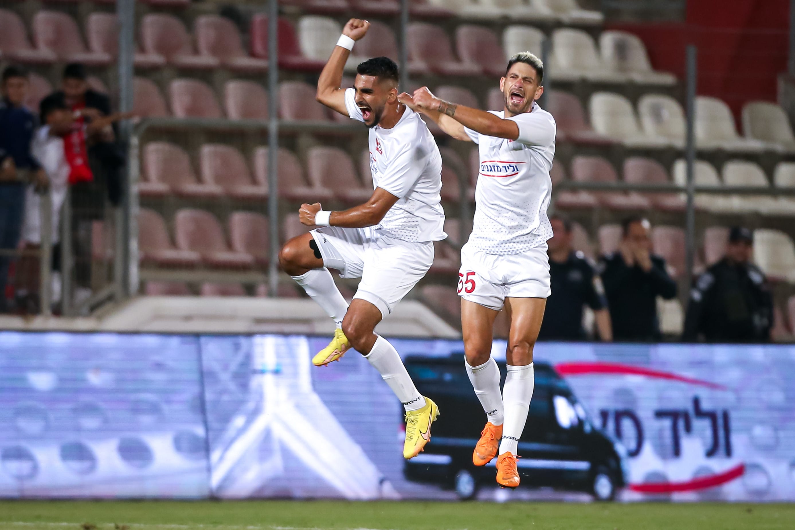 Hassan Hilo, a Bnei Sakhnin player, celebrates a disallowed goal, with Roi Shukarni behind him