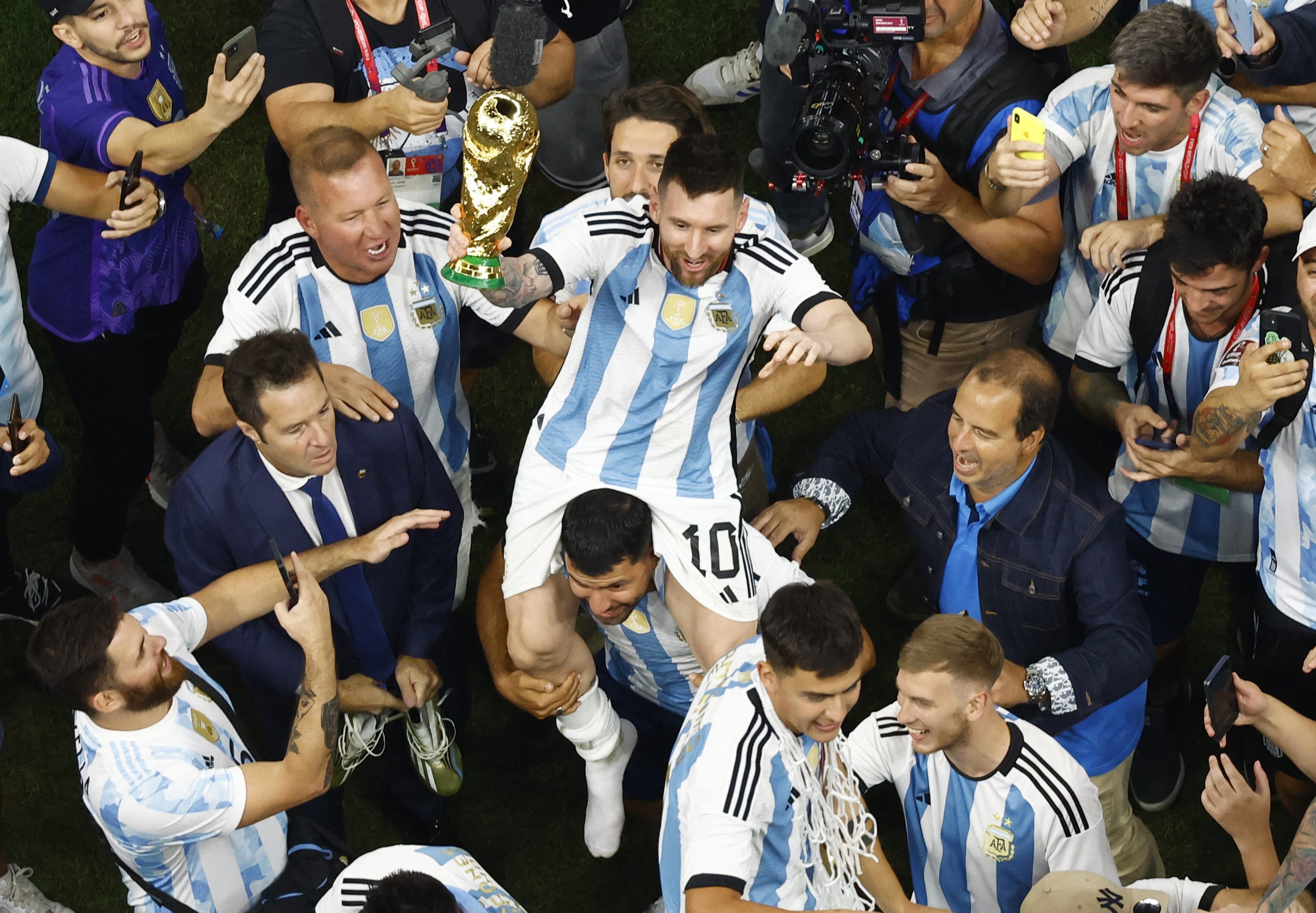 סרחיו אגוארו מרים על כתפיו את ליאונל מסי עם גביע העולם, ארגנטינה חוגגת זכייה, מונדיאל 2022