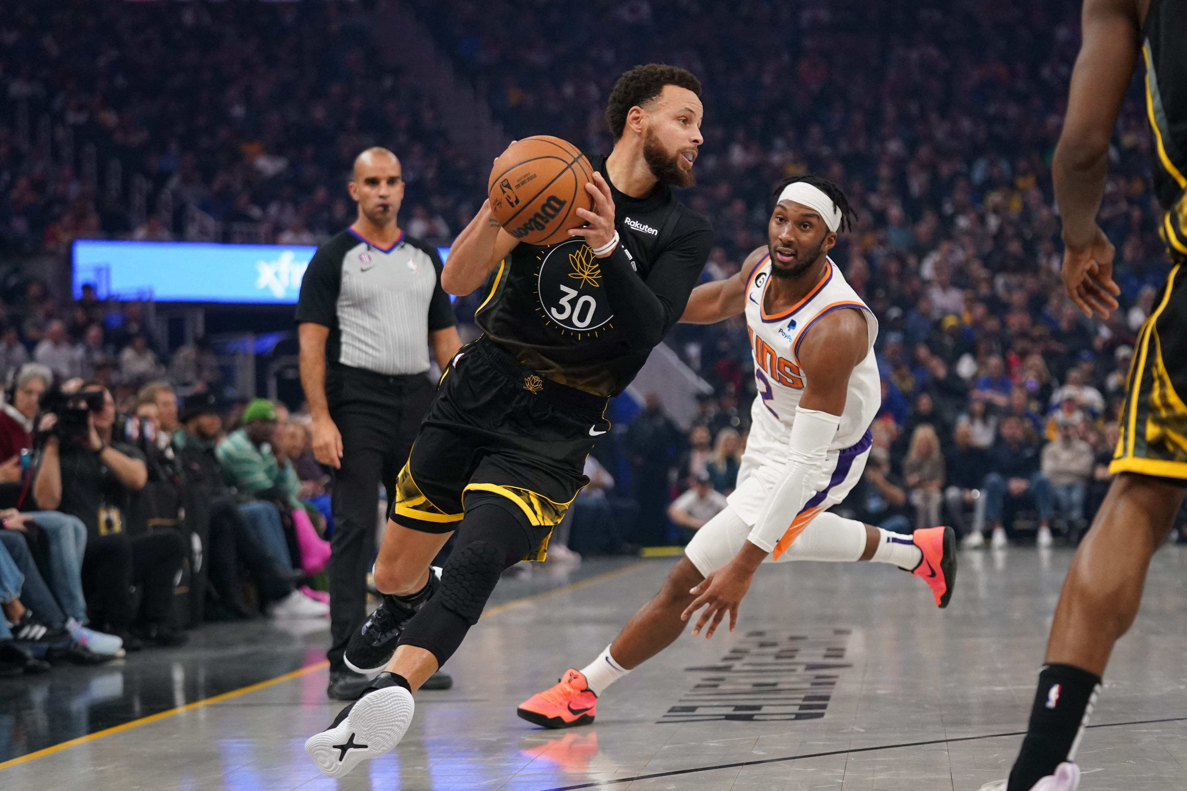 שחקן גולדן סטייט ווריירס סטפן קרי לפני שחקן פיניקס סאנס ג'וש אוקוגי