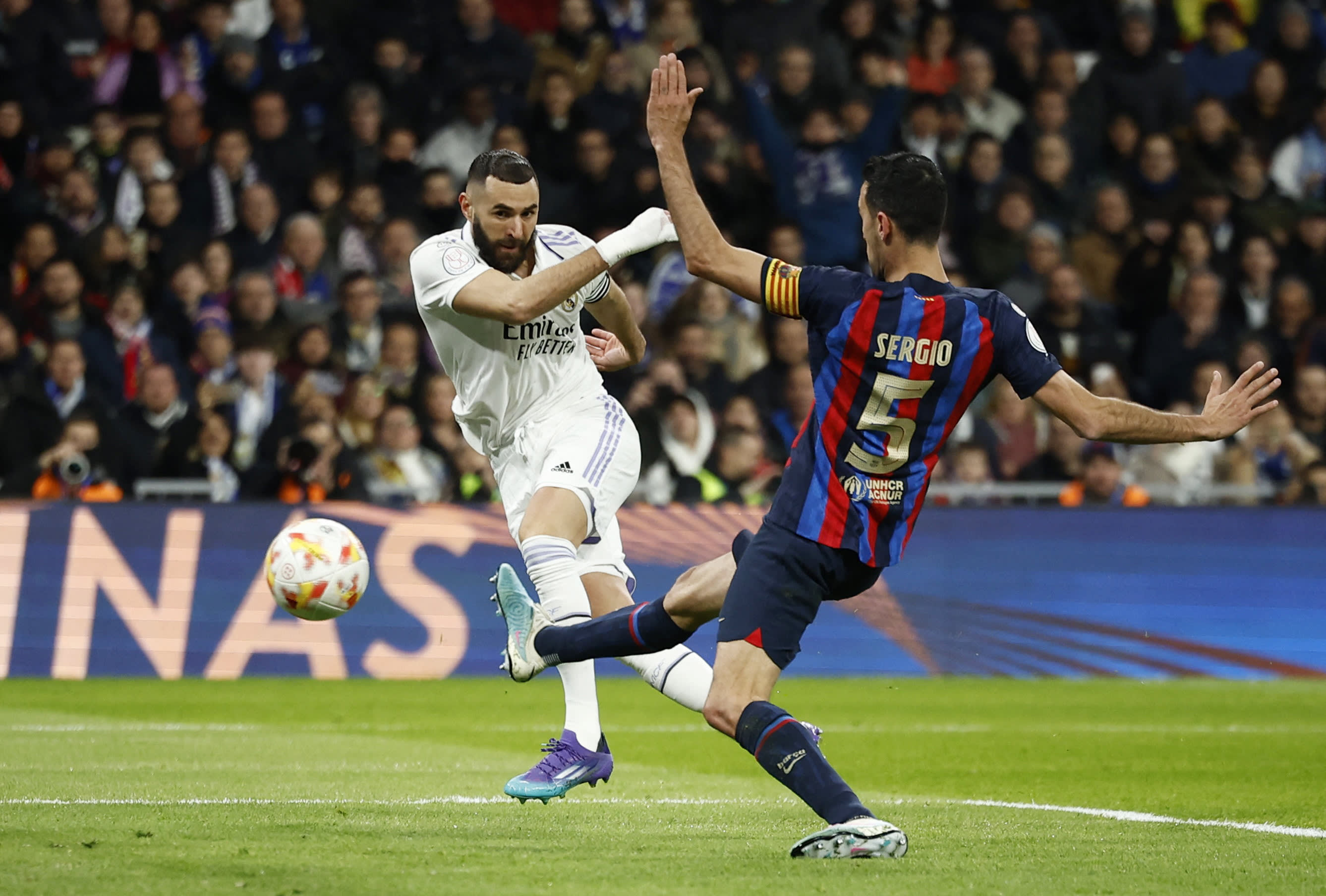 שחקן ברצלונה סרג'יו בוסקטס מנסה לחסום את שחקן ריאל מדריד קארים בנזמה