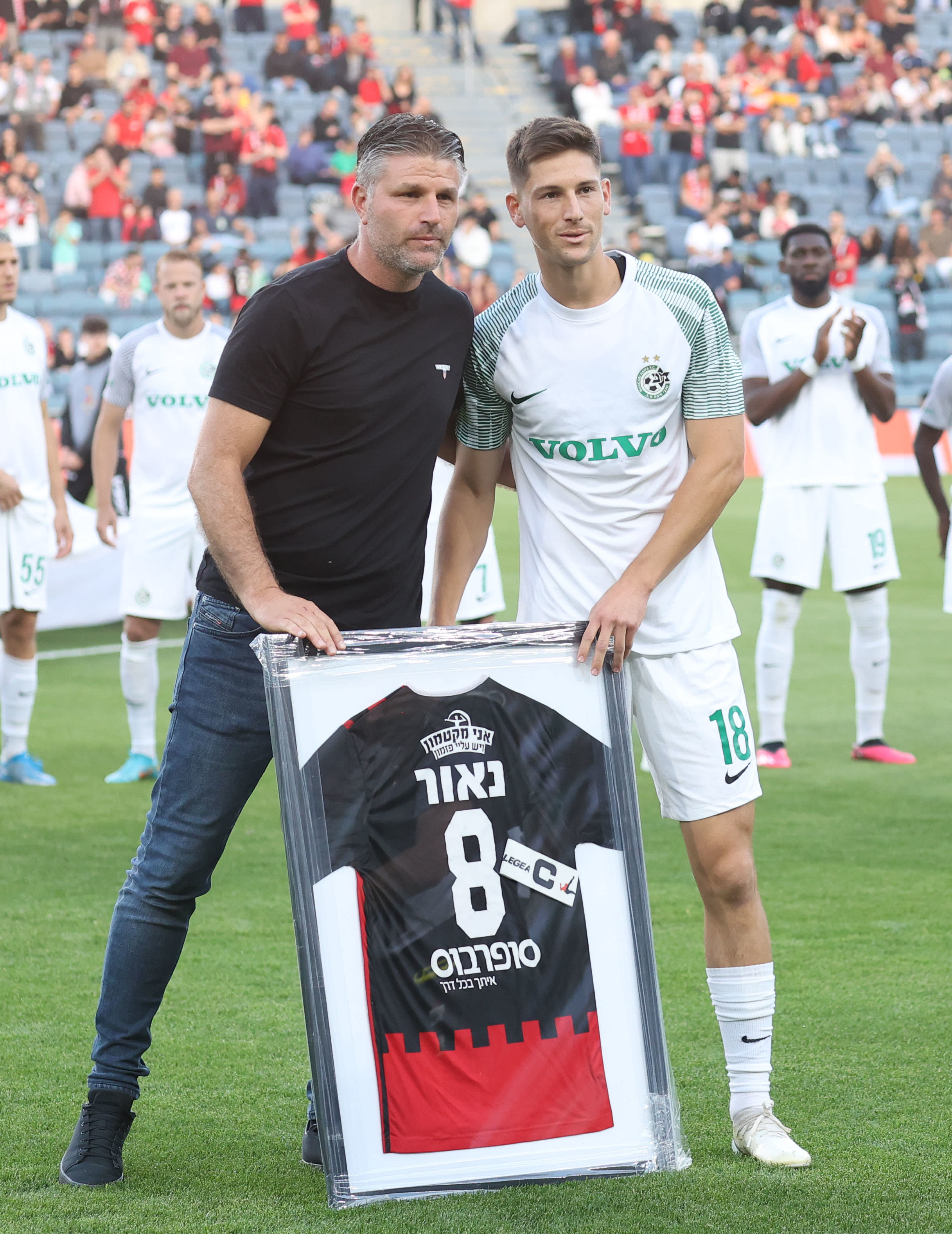 שי אהרון, מנהל מקצועי הפועל ירושלים, מעניק חולצה ממוסגרת לשחקן מכבי חיפה גוני נאור