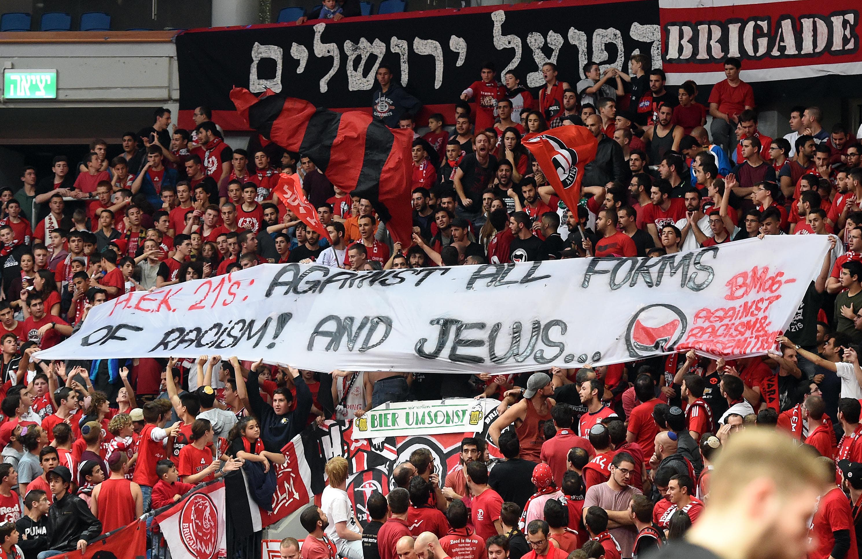 אוהדי הפועל ירושלים עם שלט נגד אוהדי א.א.ק אתונה