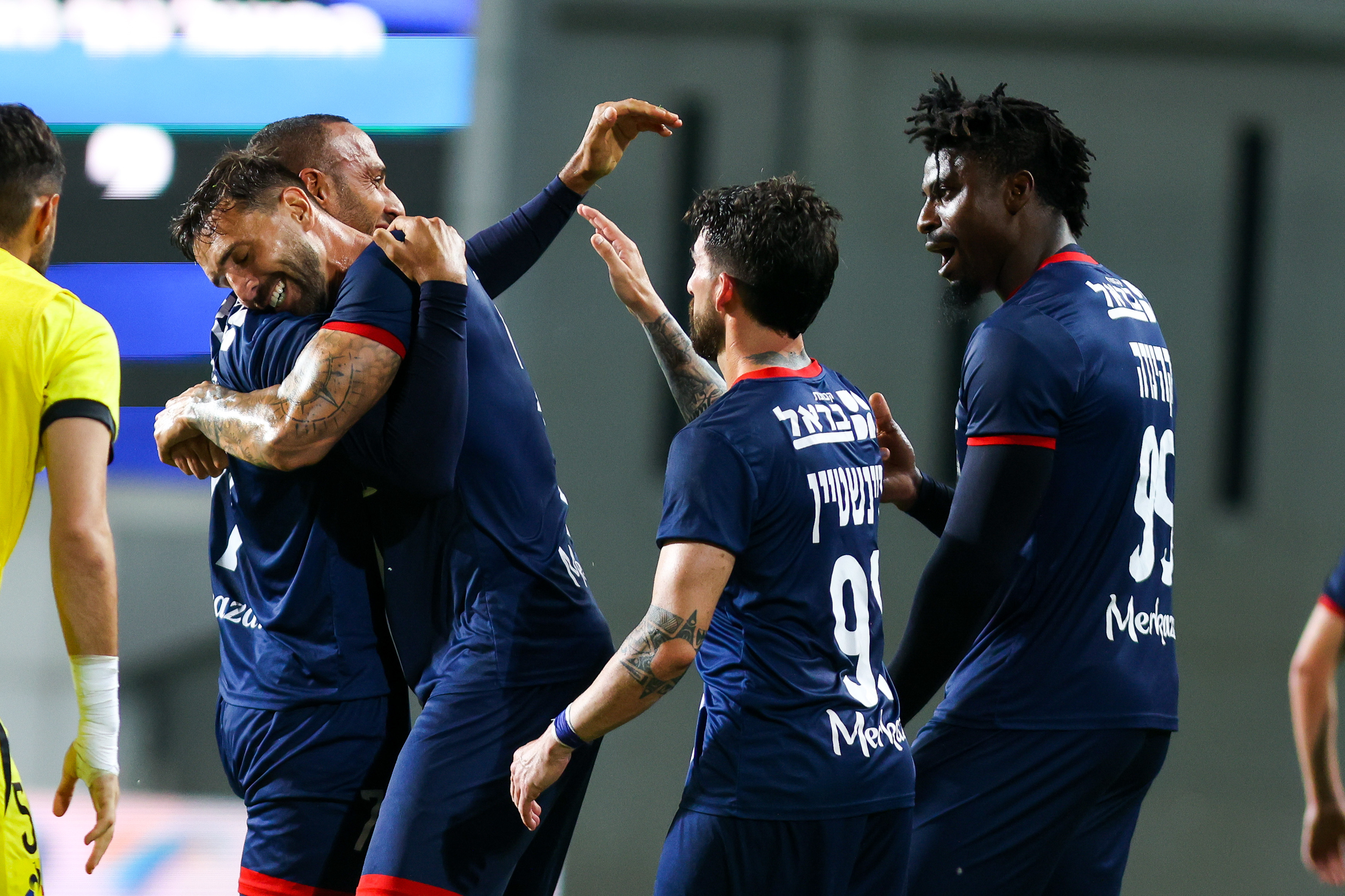 שחקני הפועל נוף הגליל חוגגים עם מהראן ראדי (משמאל)