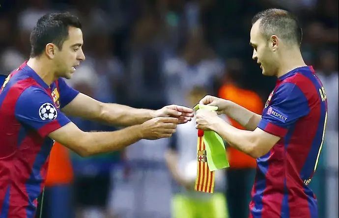 צ'אבי (משמאל) במשחקו האחרון במדי ברצלונה מקבל את סרט הקפטן מידי אנדרס אינייסטה