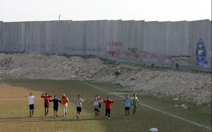 שחקני אבו דיס עם גדר ההפרדה ב-2006