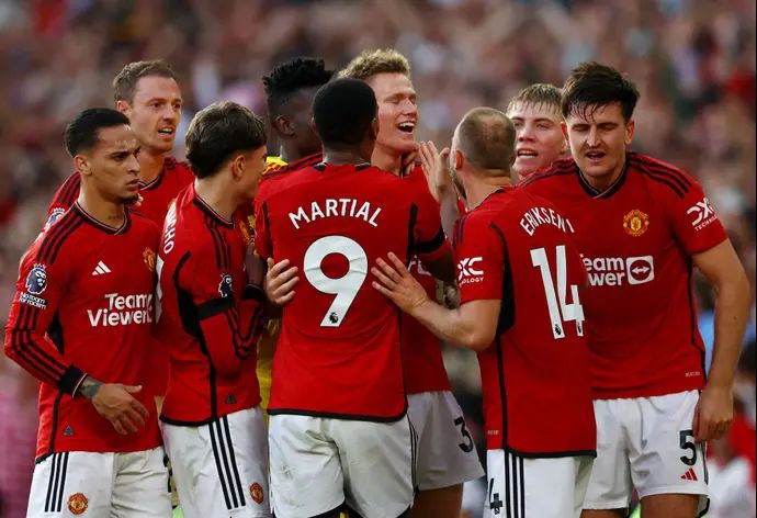 שחקני מנצ'סטר יונייטד חוגגים עם סקוט מקטומיניי