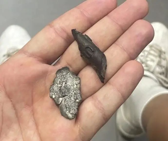 שחקן מ.ס. אשדוד מחזיק בידו רסיסי טיל שנחתו במגרש במהלך אימון הקבוצה