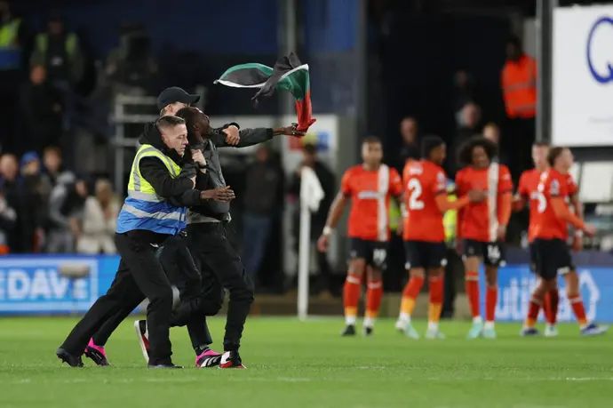 אוהד פורץ לדשא עם דגל פלסטין בחגיגות לוטון