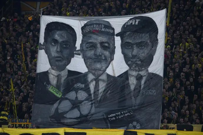 אוהדי דורטמונד מוחים נגד אופ"א והכסף בכדורגל - עם שלט שכולל את אינפנטינו, אל חלאיפי, אניילי