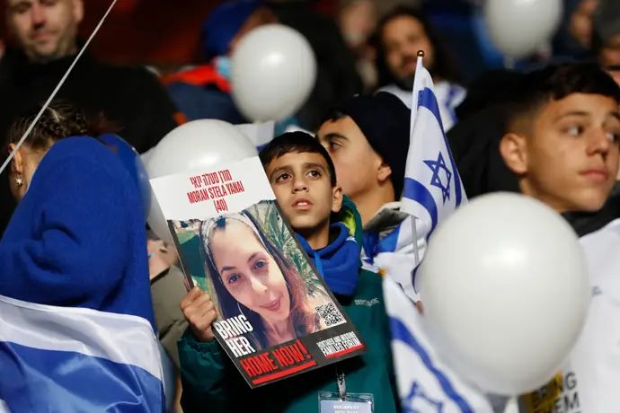 אוהדי נבחרת ישראל עם תמונות החטופים