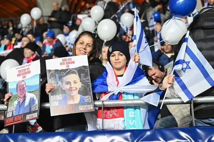 אוהדי נבחרת ישראל עם תמונות החטופים