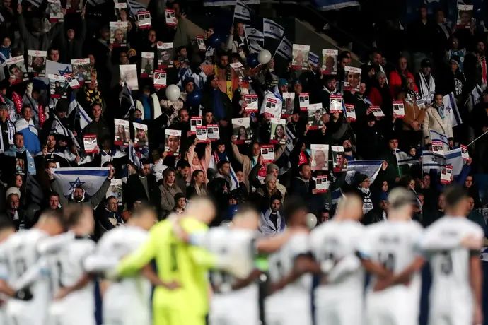 אוהדי נבחרת ישראל עם תמונות החטופים