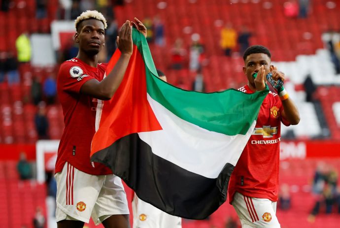 שחקן מנצ'סטר יונייטד פול פוגבה עם אמאד דיאלו מניפים את דגל פלסטין לאחר המשחק מול פולהאם